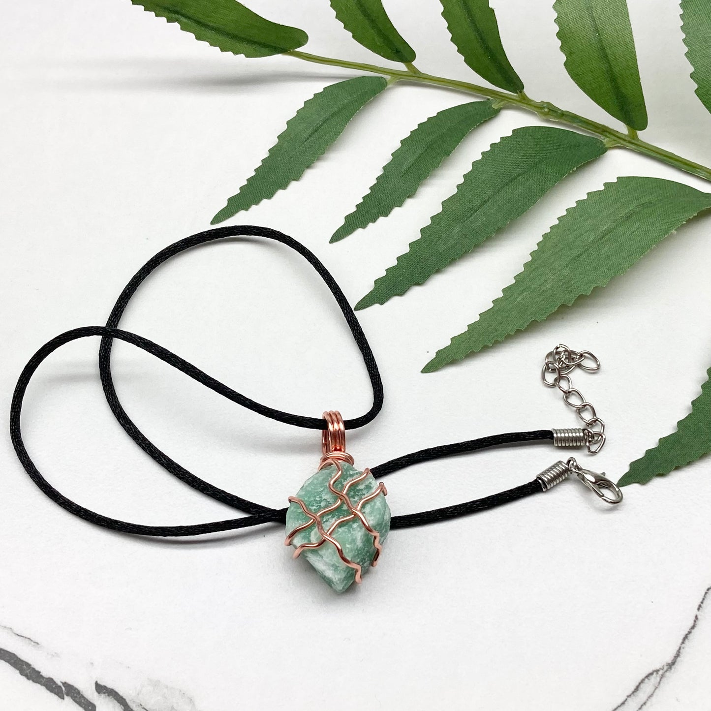 Green Aventurine Necklace. Raw Green Aventurine crystal wrapped with copper wire. Comes on a black chain.