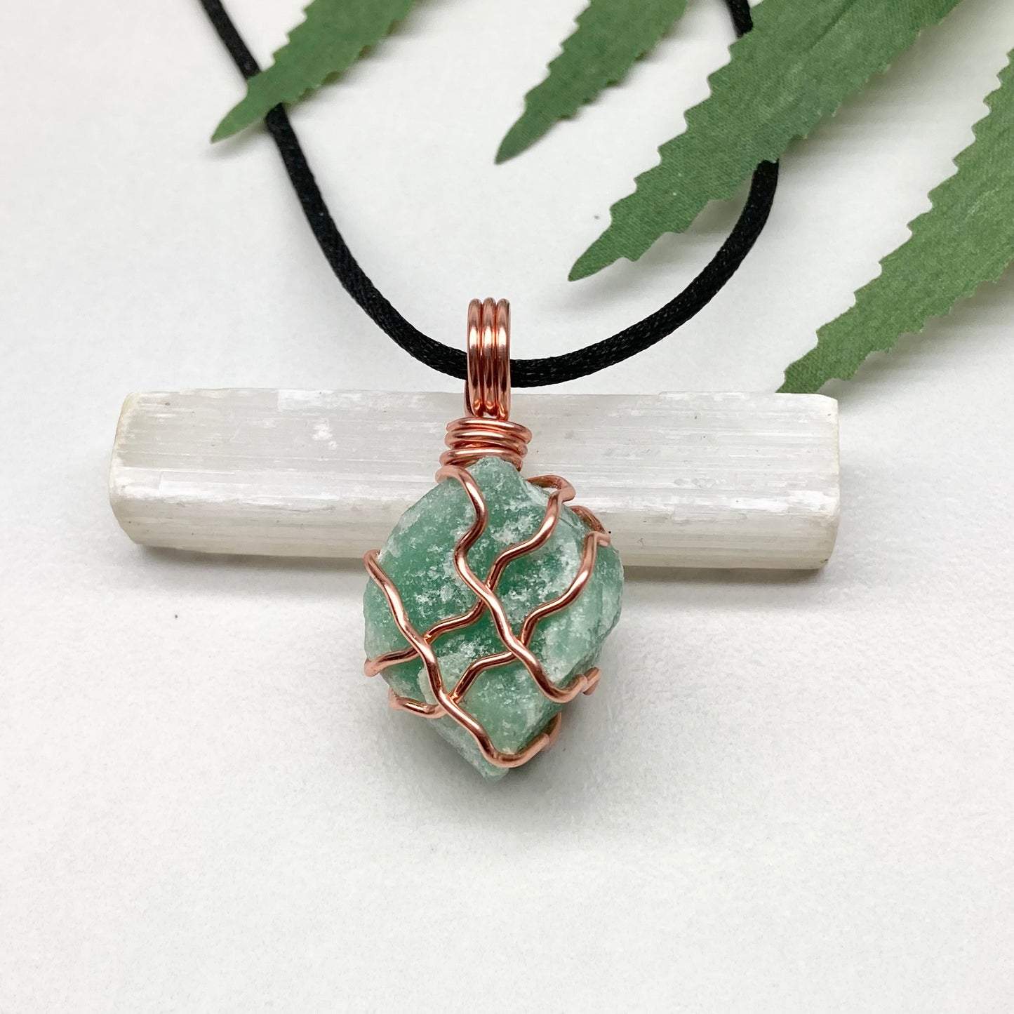 Green Aventurine Necklace. Raw Green Aventurine crystal wrapped with copper wire. Comes on a black chain.
