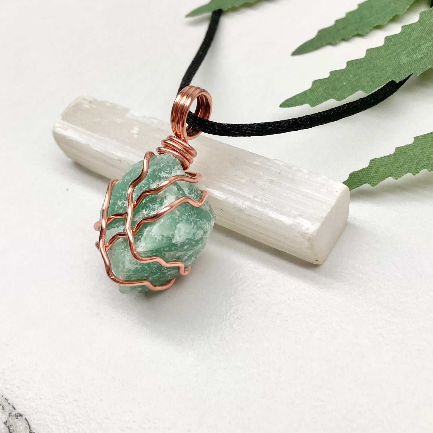 Green Aventurine Necklace. Raw Green Aventurine crystal wrapped with copper wire. Comes on a black chain.