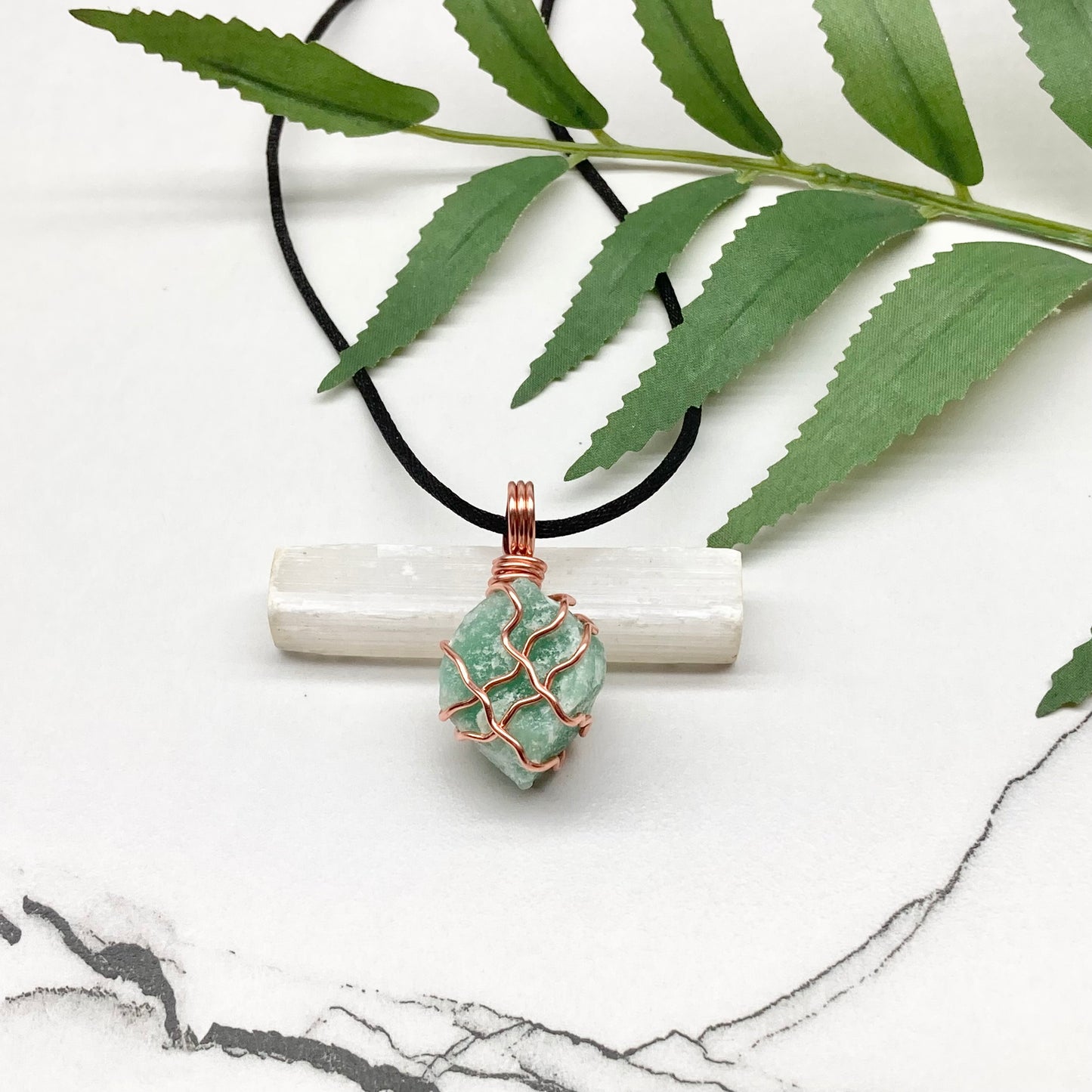Green Aventurine Necklace. Raw Green Aventurine crystal wrapped with copper wire. Comes on a black chain.