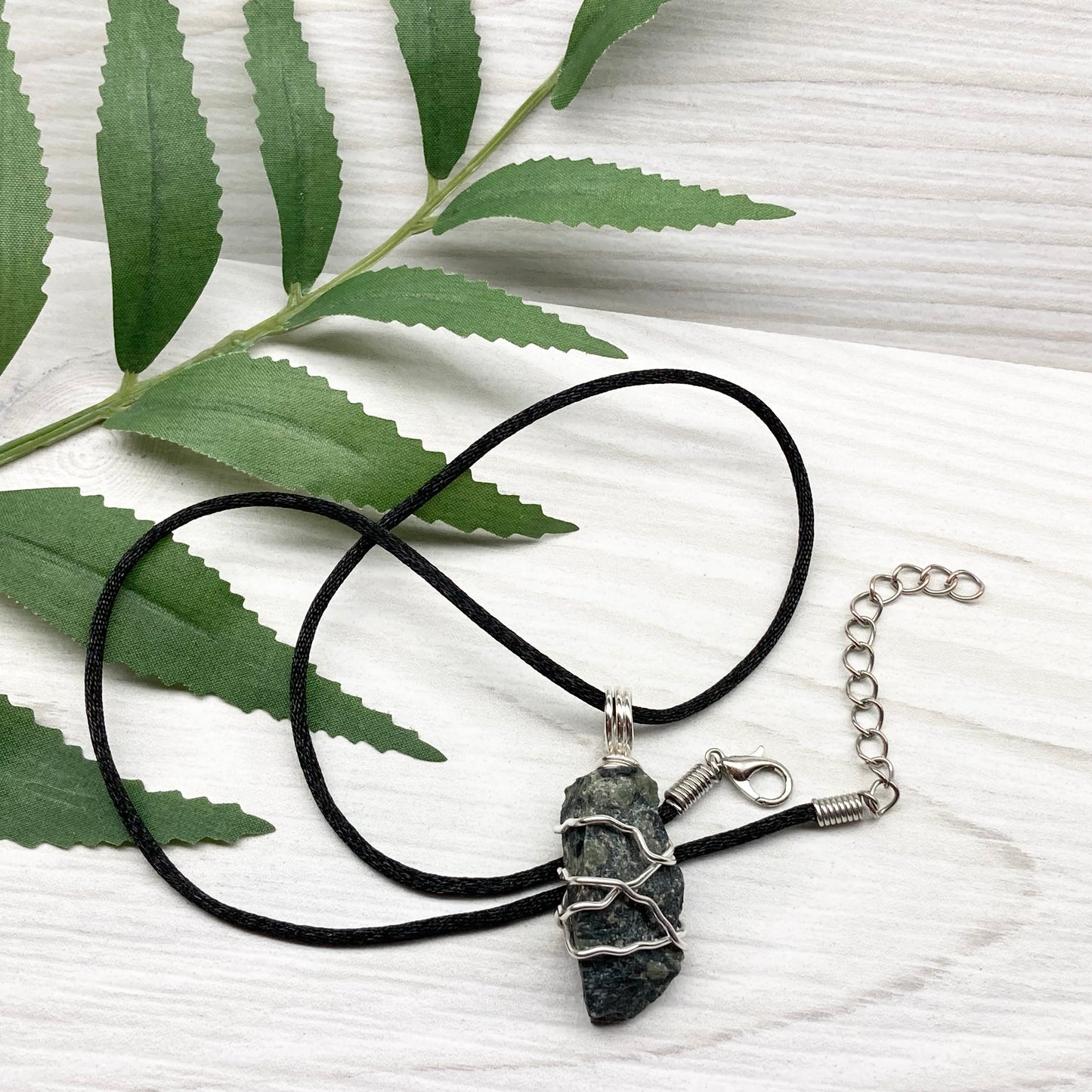 Kambaba Jasper necklace. Raw Kambaba Jasper stone wrapped with silver colored copper wire. Hangs on a black satin silk chain. Wire wrapped green and black crystal copper pendant. Handcrafted metaphysical jewelry.