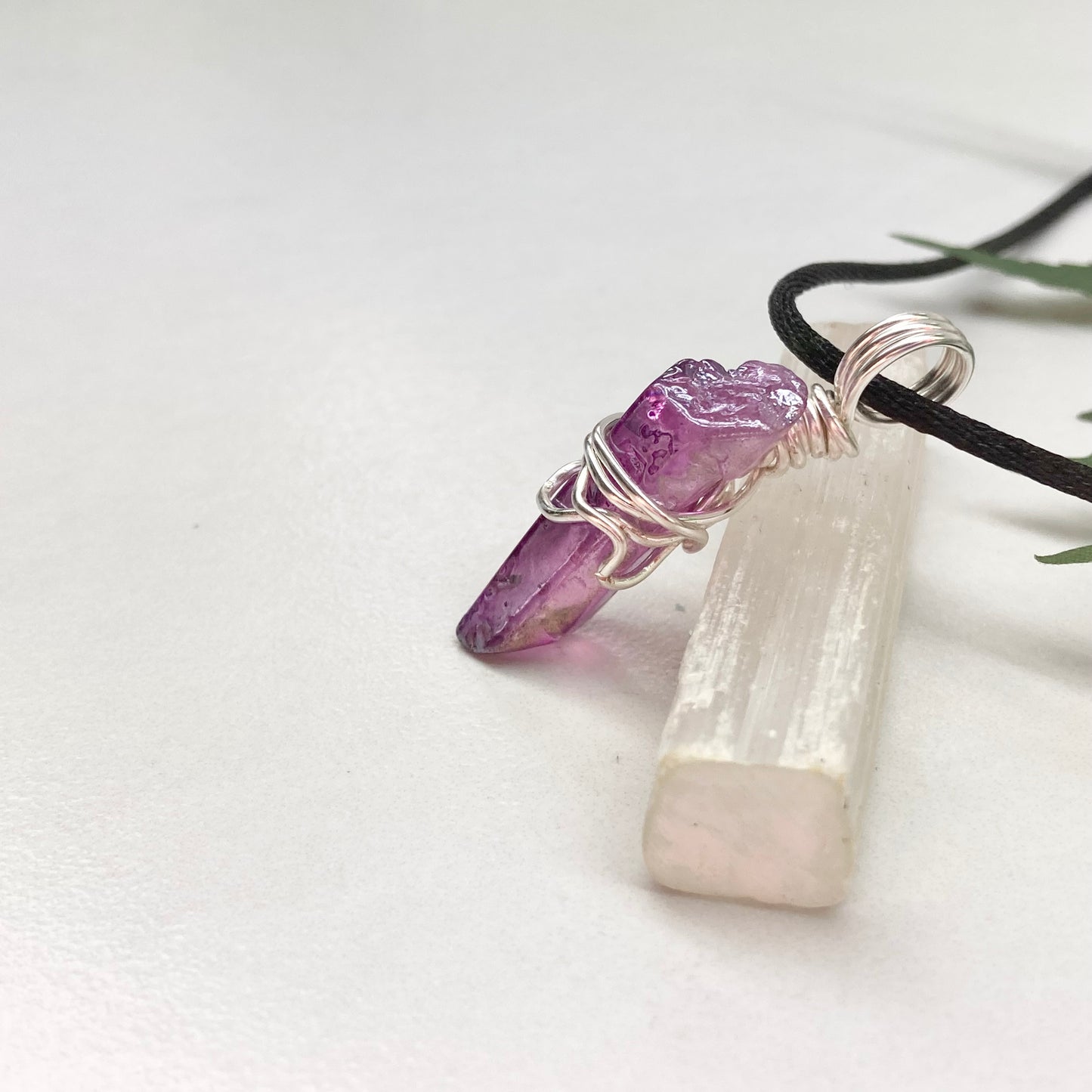 Hand-wrapped purple aura quartz pendant in silver-colored copper wire on a satin silk chain.