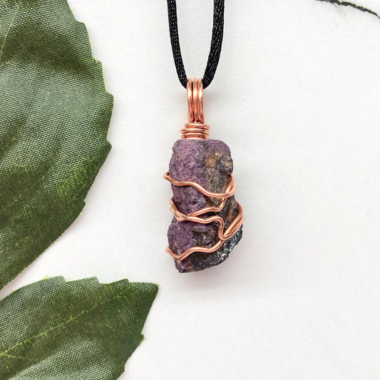 Raw purpurite crystal necklace wrapped in pure copper wire, handcrafted during the New Moon in Taurus, displayed on a white background.