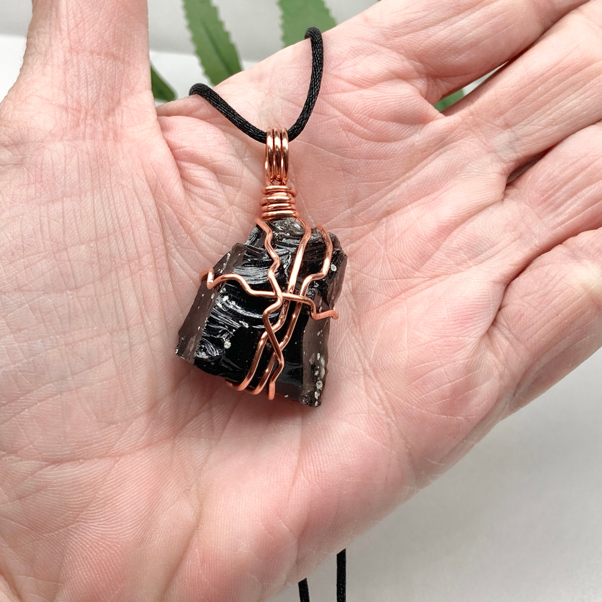 Snowflake Obsidian necklace. Black stone with gray spots wrapped with pure copper wire. Hangs on a black chain. Spiritual handmade jewelry.