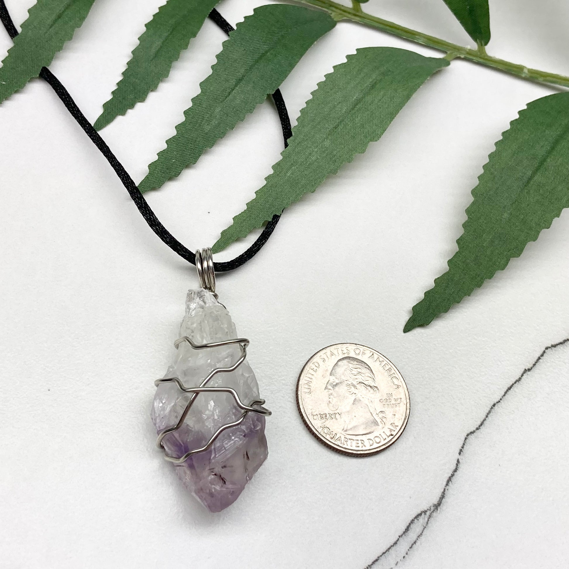 Amethyst tip necklace. Beautiful unique crystal that is Clear Quartz for the top half and purple amethyst for the bottom half. Crystal is wrapped with silver copper wire. Hangs on a black chain.