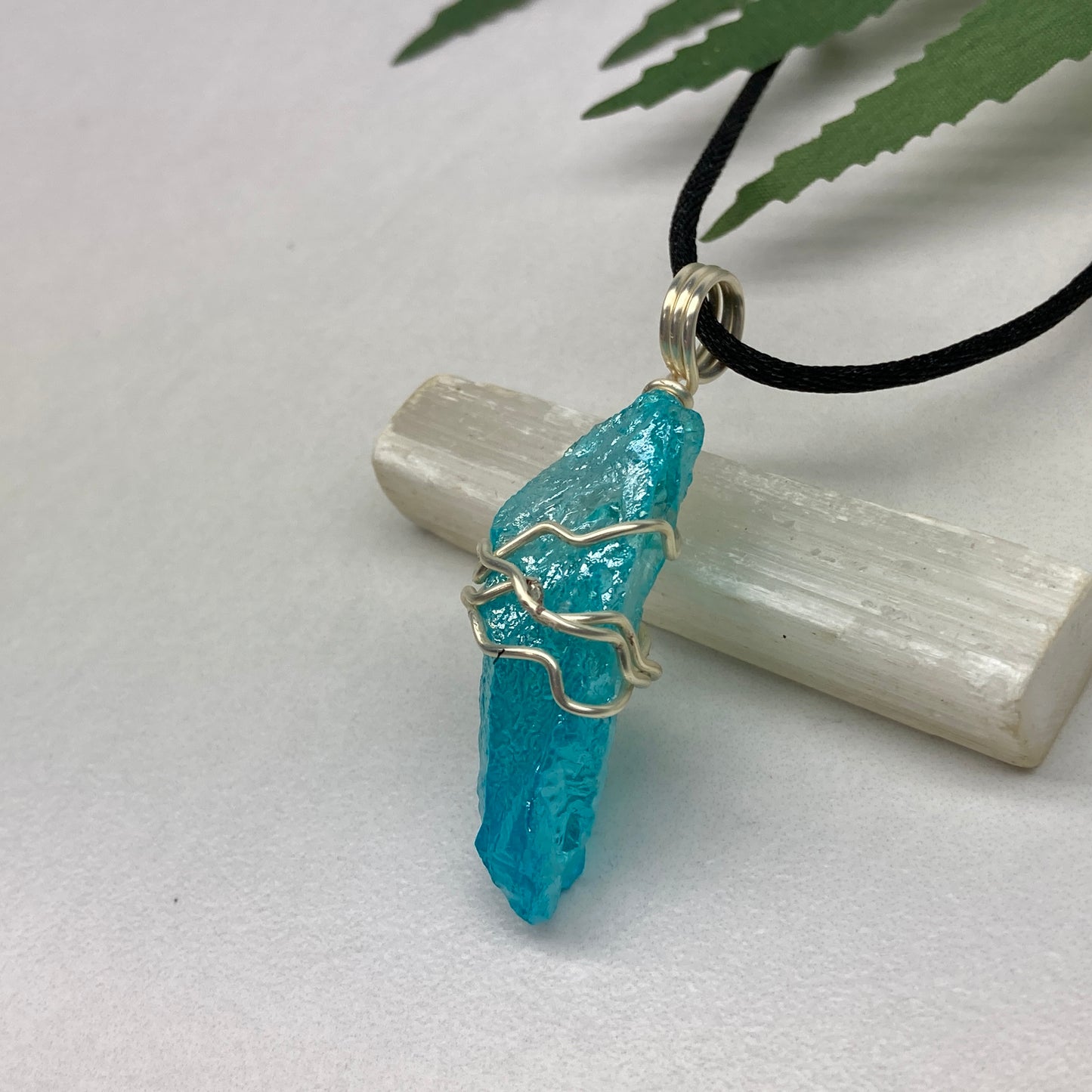Aqua Aura Quartz crystal necklace wrapped in silver colored copper wire on a black satin silk necklace. Handmade during the Moon in Taurus.