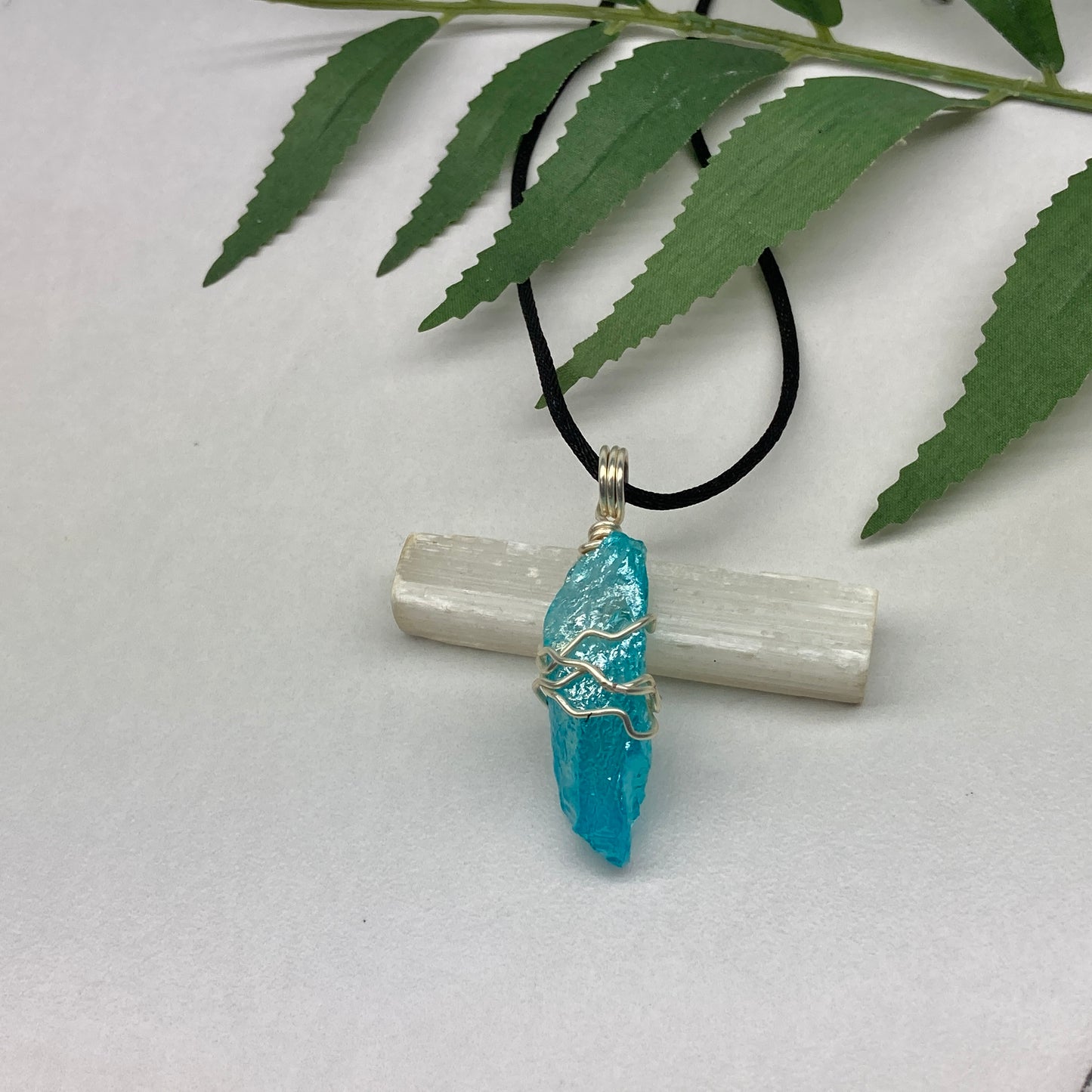 Aqua Aura Quartz crystal necklace wrapped in silver colored copper wire on a black satin silk necklace. Handmade during the Moon in Taurus.