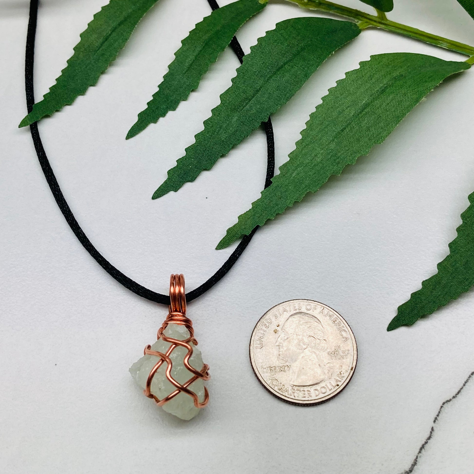Aquamarine necklace. Raw light mint green stone wrapped with pure copper wire. Hangs on a black chain. Wire wrapped crystal jewelry.