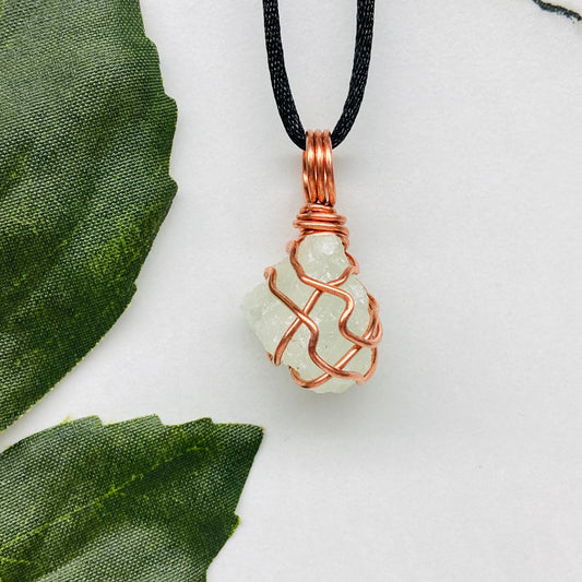 Aquamarine necklace. Raw light mint green stone wrapped with pure copper wire. Hangs on a black chain. Wire wrapped crystal jewelry.