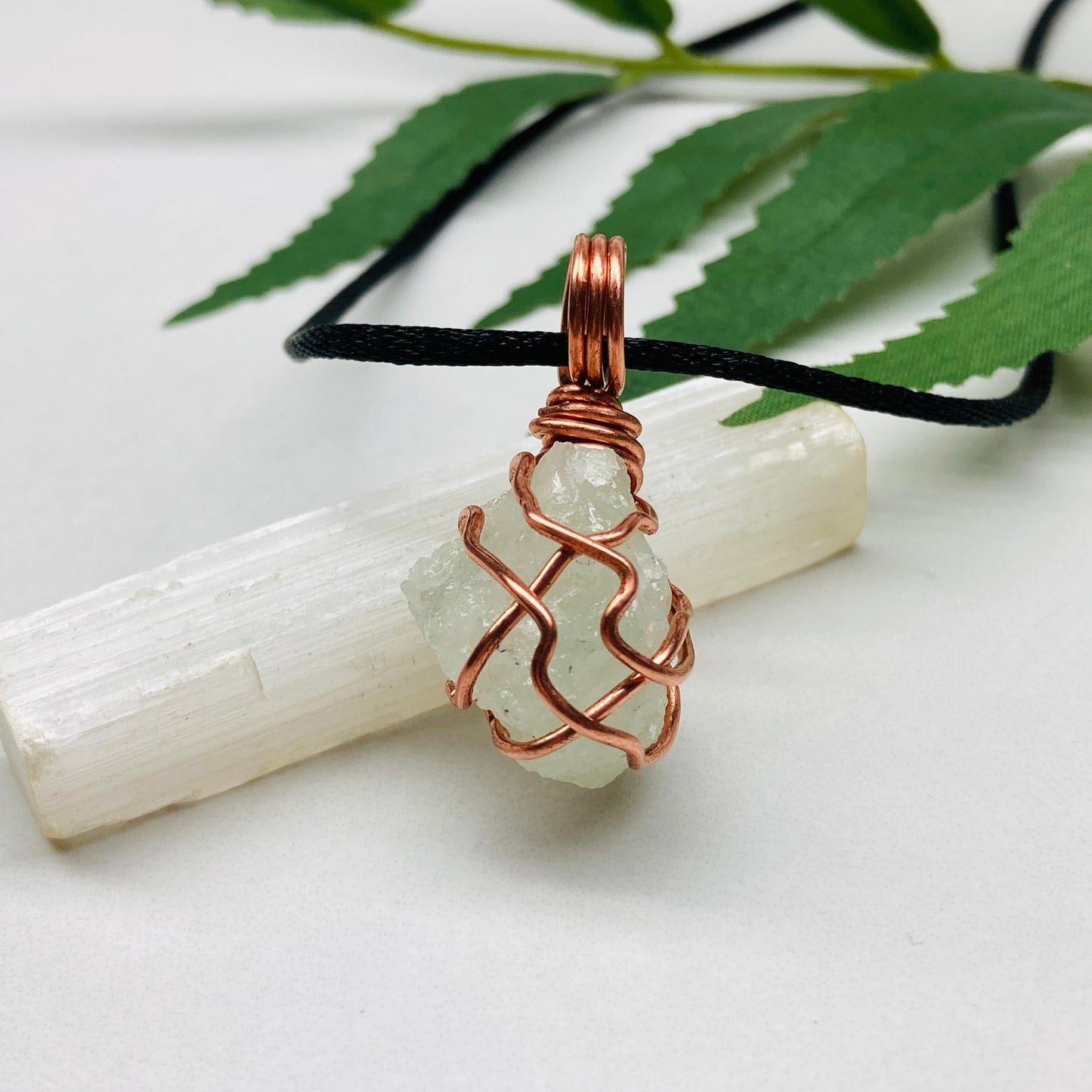 Aquamarine necklace. Raw light mint green stone wrapped with pure copper wire. Hangs on a black chain. Wire wrapped crystal jewelry.