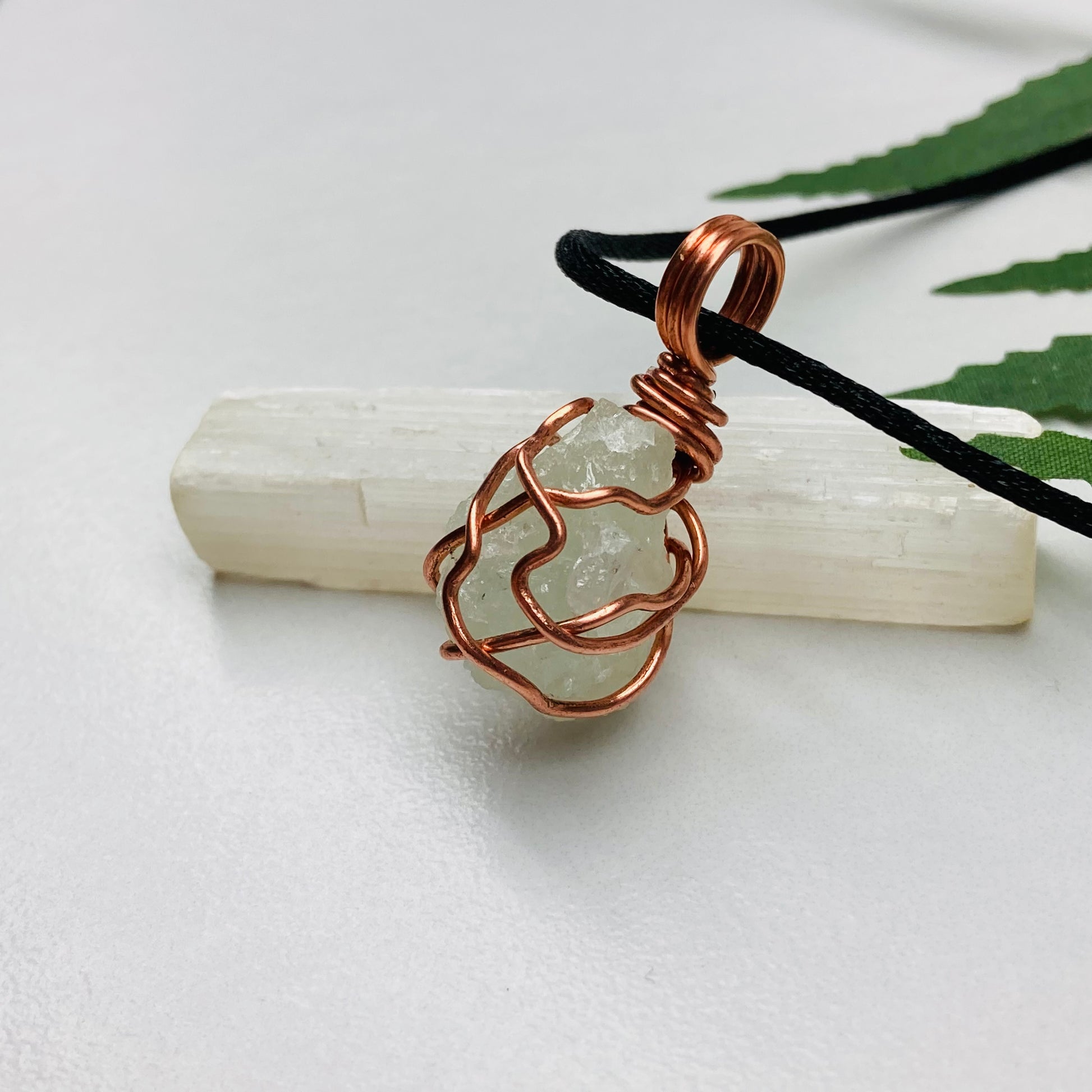 Aquamarine necklace. Raw light mint green stone wrapped with pure copper wire. Hangs on a black chain. Wire wrapped crystal jewelry.