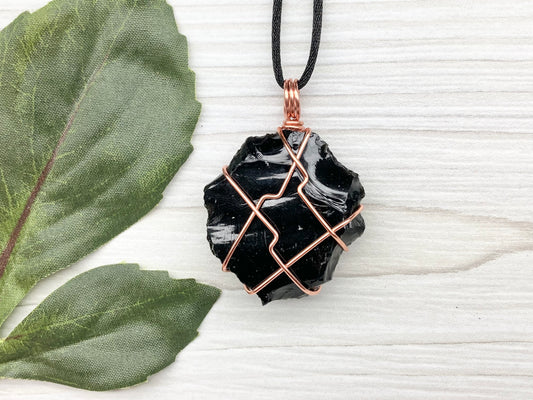 Raw black obsidian necklace. Natural black crystal wrapped with copper wire. Comes on a black necklace.
