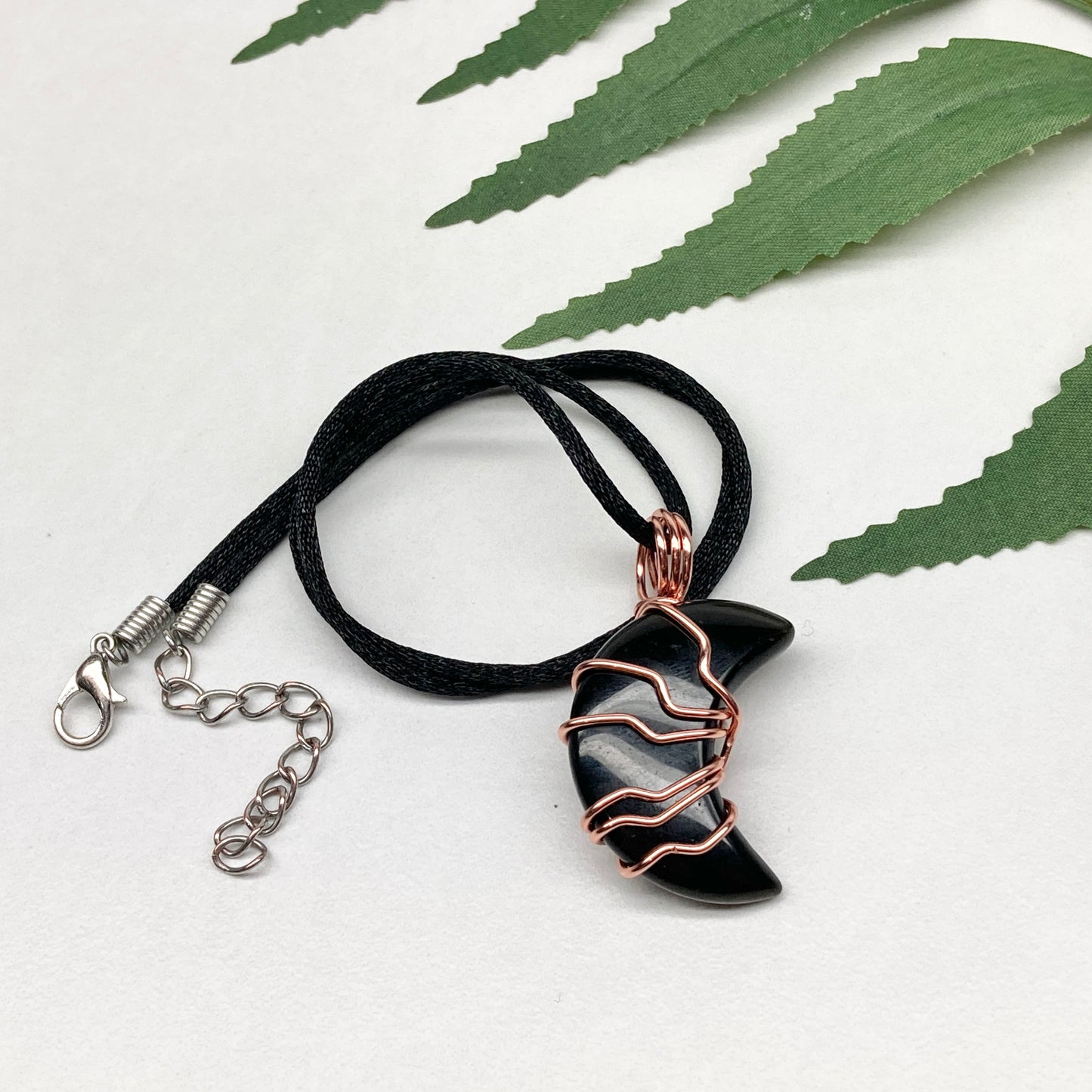 Black Onyx Moon necklace. Moon shaped Black Onyx crystal wrapped with tarnish resistant copper wire. Hangs on a black chain. Celestial Jewelry.