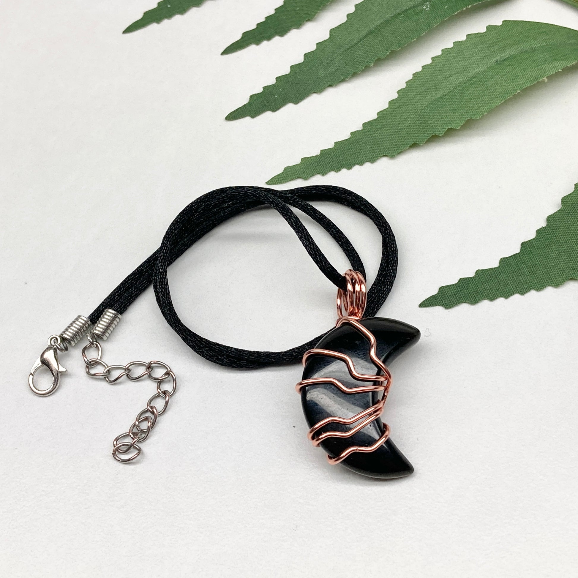 Black Onyx Moon necklace. Moon shaped Black Onyx crystal wrapped with tarnish resistant copper wire. Hangs on a black chain. Celestial Jewelry.