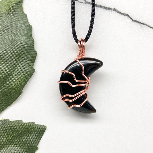 Black Onyx Moon necklace. Moon shaped Black Onyx crystal wrapped with tarnish resistant copper wire. Hangs on a black chain. Celestial Jewelry.