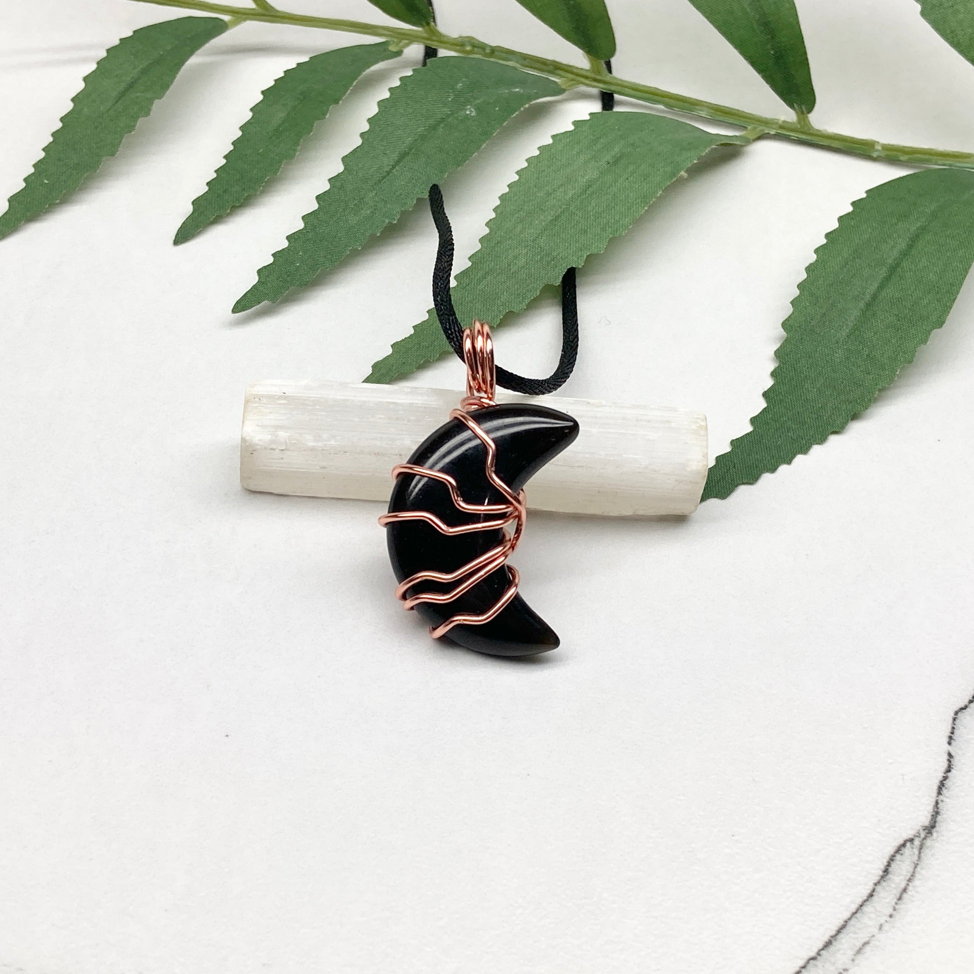 Black Onyx Moon necklace. Moon shaped Black Onyx crystal wrapped with tarnish resistant copper wire. Hangs on a black chain. Celestial Jewelry.