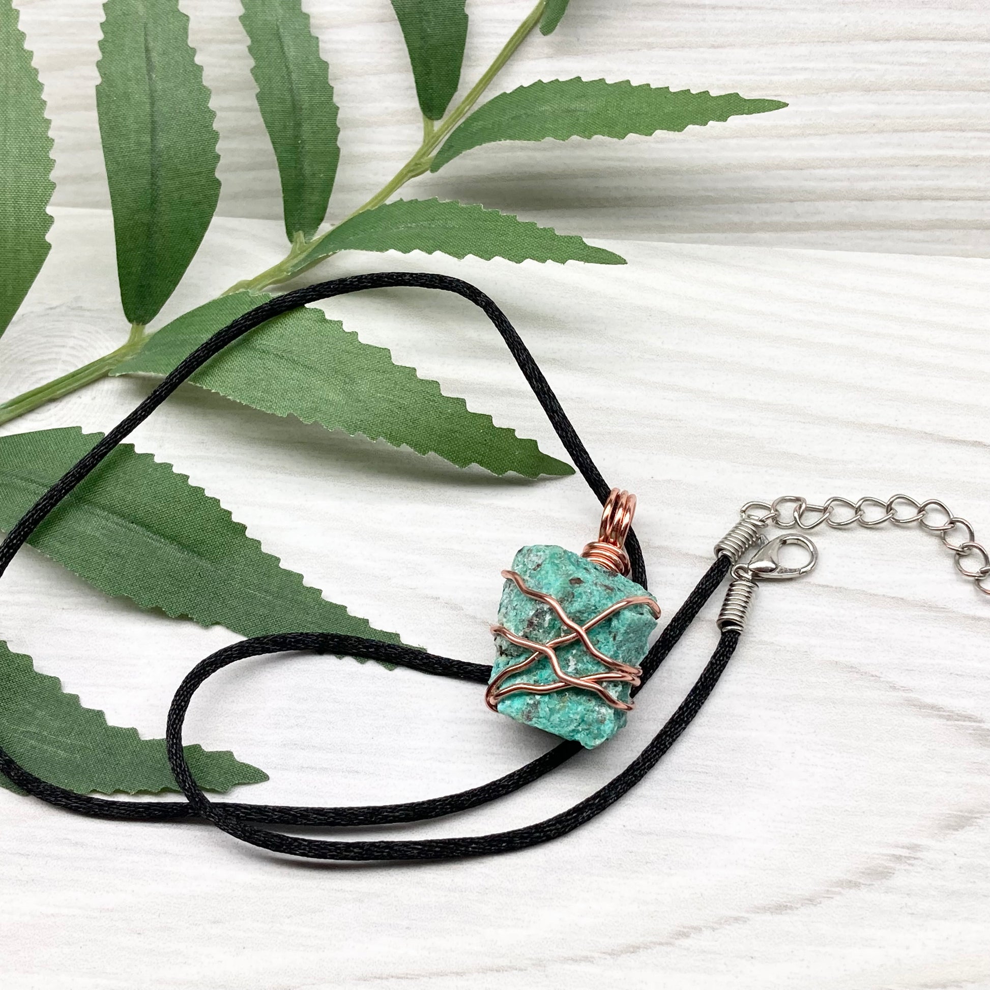Chrysocolla necklace. Raw blue green stone wrapped in copper wire. Pendant hangs on a satin silk chain.
