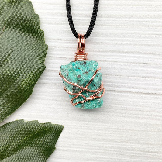 Chrysocolla necklace. Raw blue green stone wrapped in copper wire. Pendant hangs on a satin silk chain.
