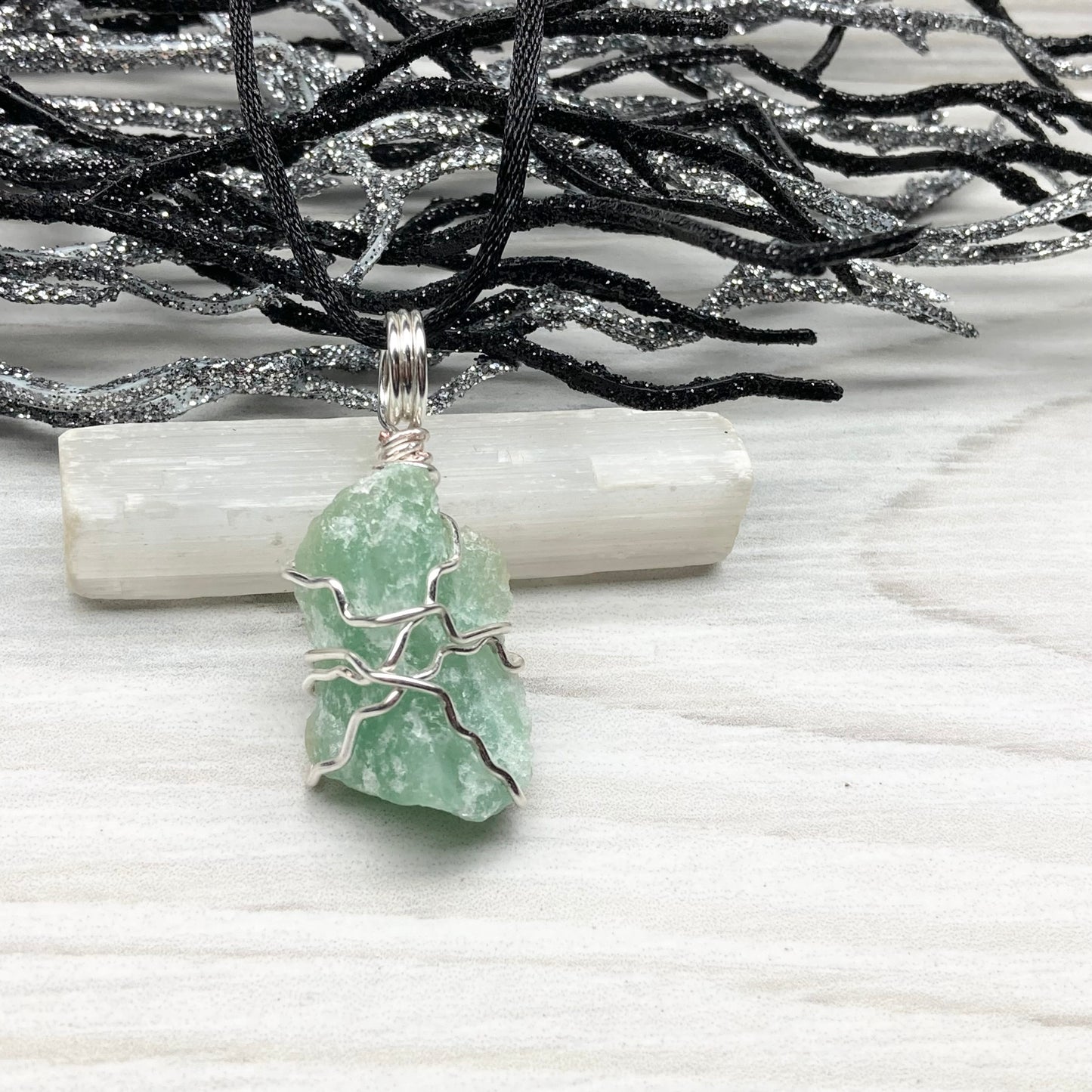 Green Aventurine necklace. Raw Green Aventurine stone wrapped with silver colored copper wire. Comes on a black chain. Wire wrapped green crystal pendant. 
