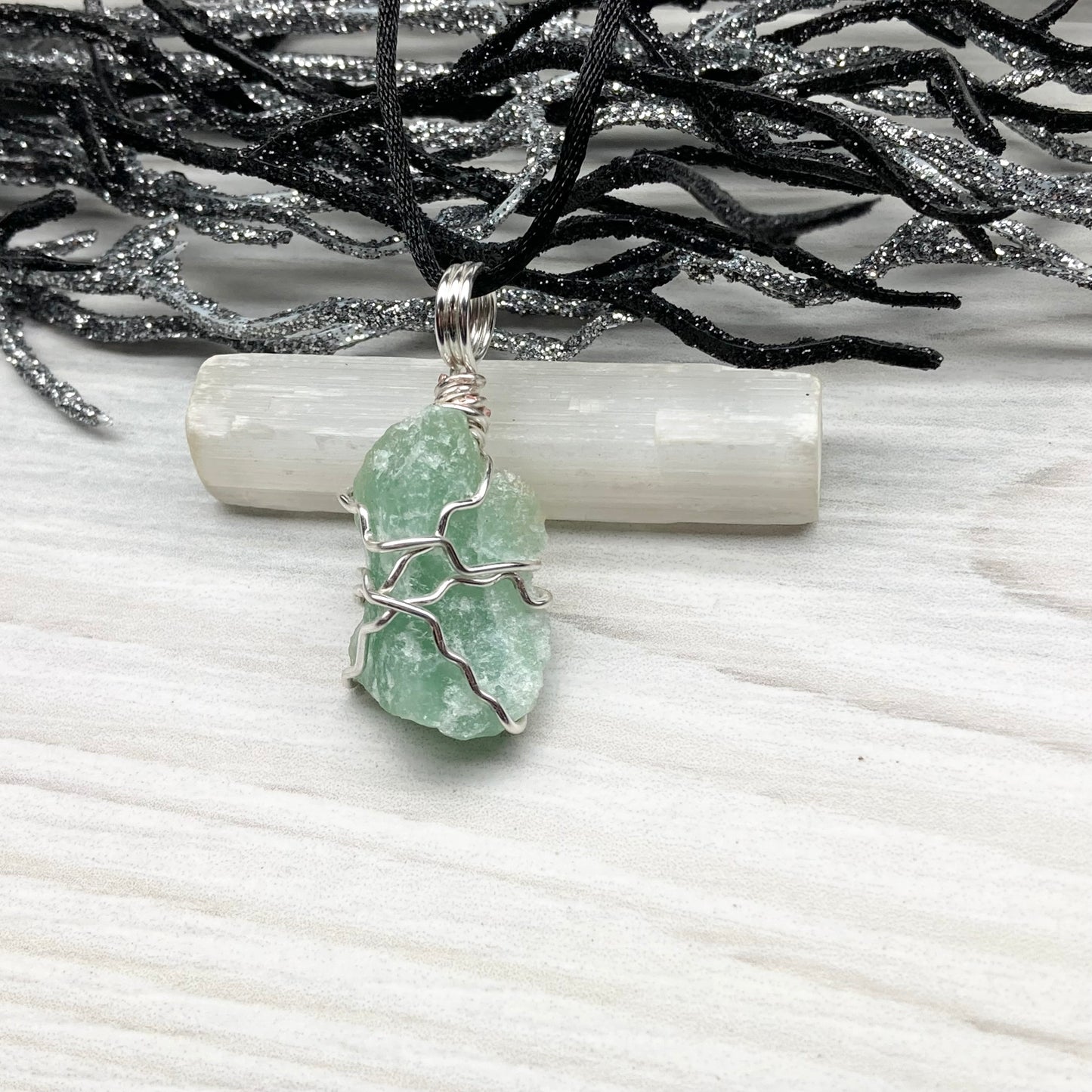 Green Aventurine necklace. Raw Green Aventurine stone wrapped with silver colored copper wire. Comes on a black chain. Wire wrapped green crystal pendant. 