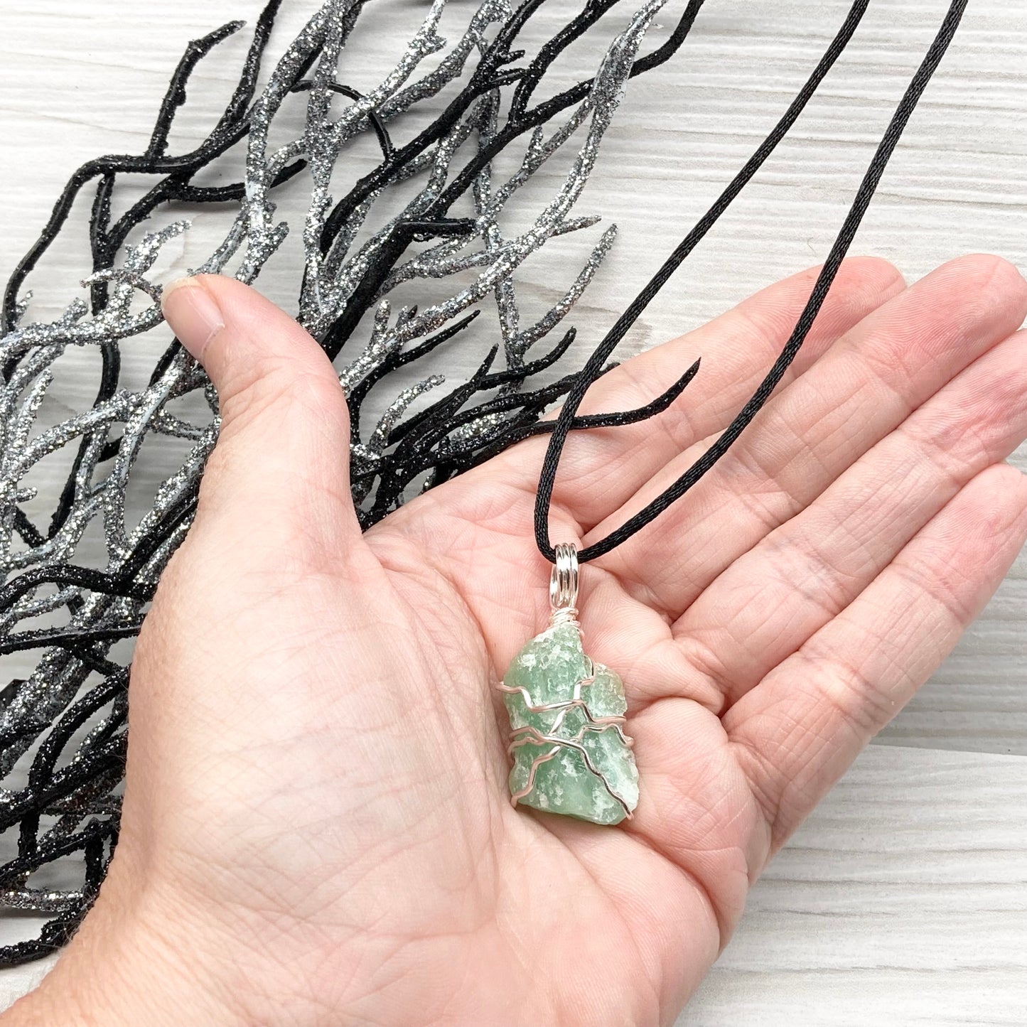 Green Aventurine necklace. Raw Green Aventurine stone wrapped with silver colored copper wire. Comes on a black chain. Wire wrapped green crystal pendant. 