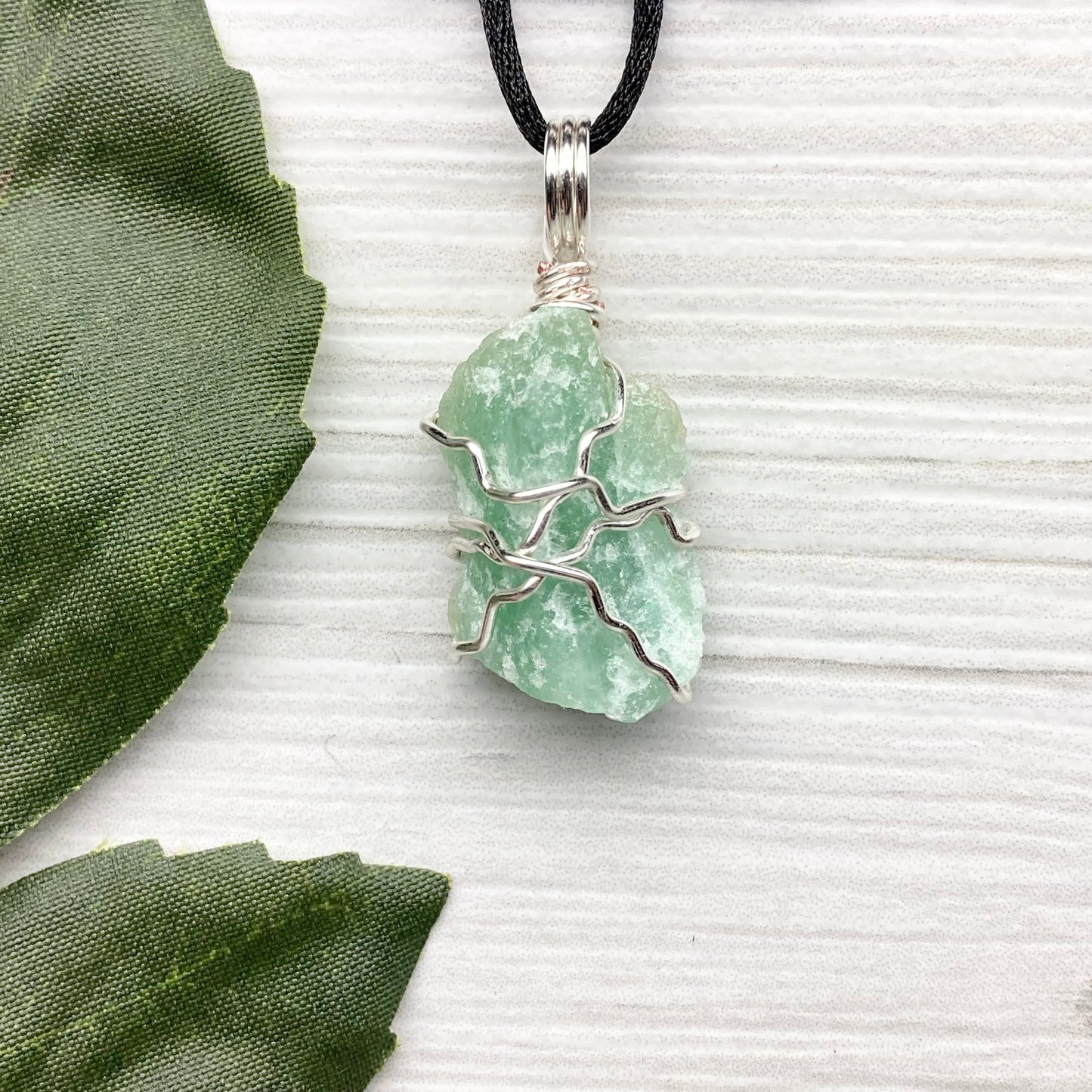Green Aventurine necklace. Raw Green Aventurine stone wrapped with silver colored copper wire. Comes on a black chain. Wire wrapped green crystal pendant. 