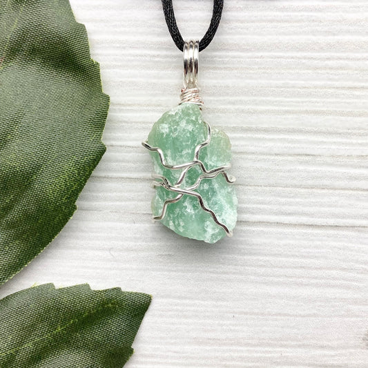 Green Aventurine necklace. Raw Green Aventurine stone wrapped with silver colored copper wire. Comes on a black chain. Wire wrapped green crystal pendant. 