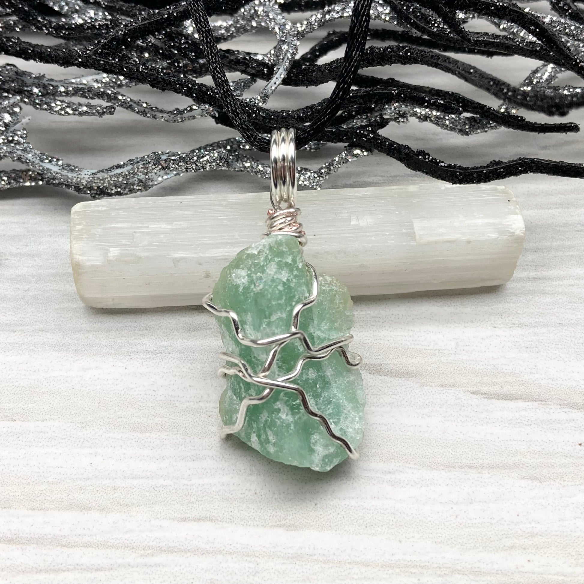 Green Aventurine necklace. Raw Green Aventurine stone wrapped with silver colored copper wire. Comes on a black chain. Wire wrapped green crystal pendant. 