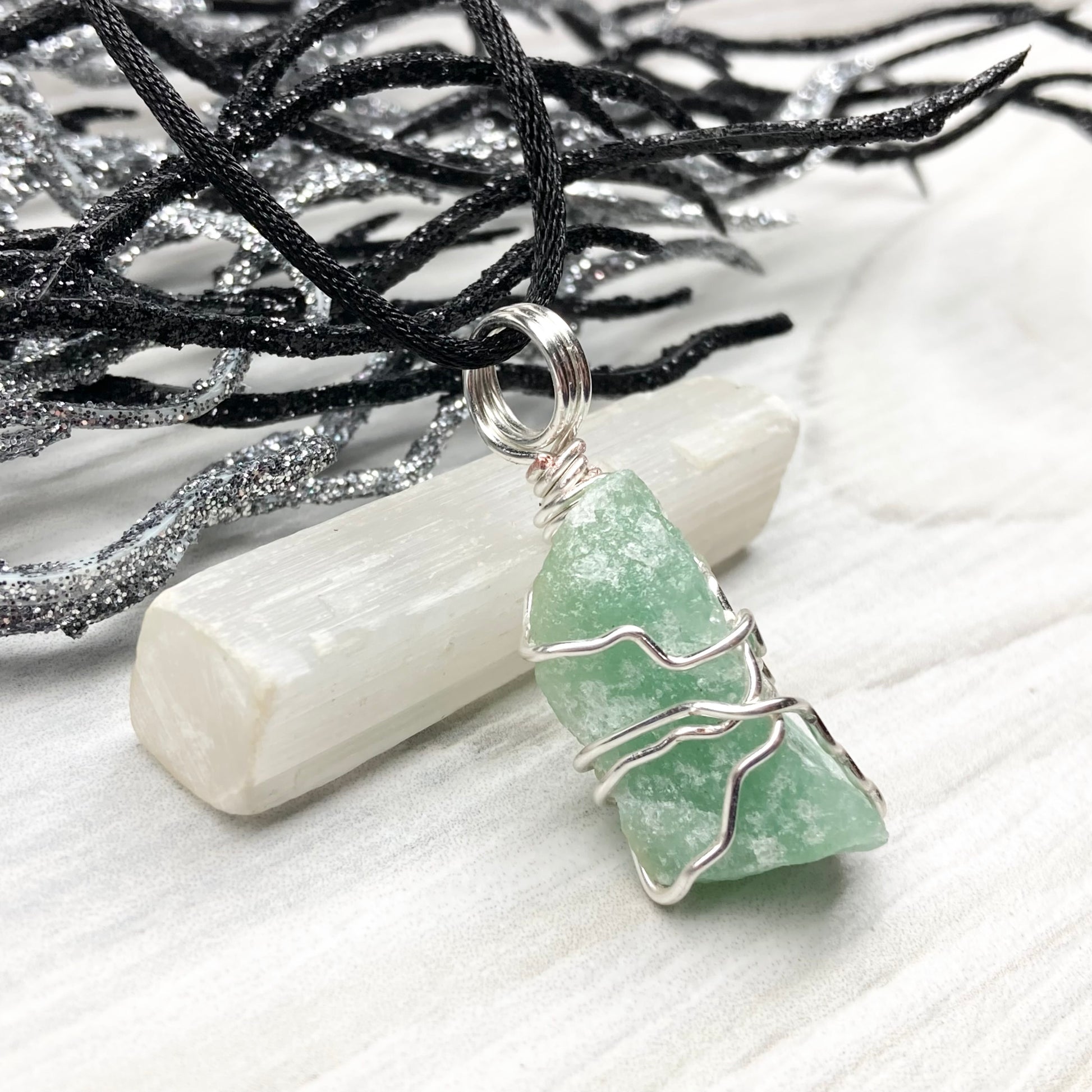 Green Aventurine necklace. Raw Green Aventurine stone wrapped with silver colored copper wire. Comes on a black chain. Wire wrapped green crystal pendant. 