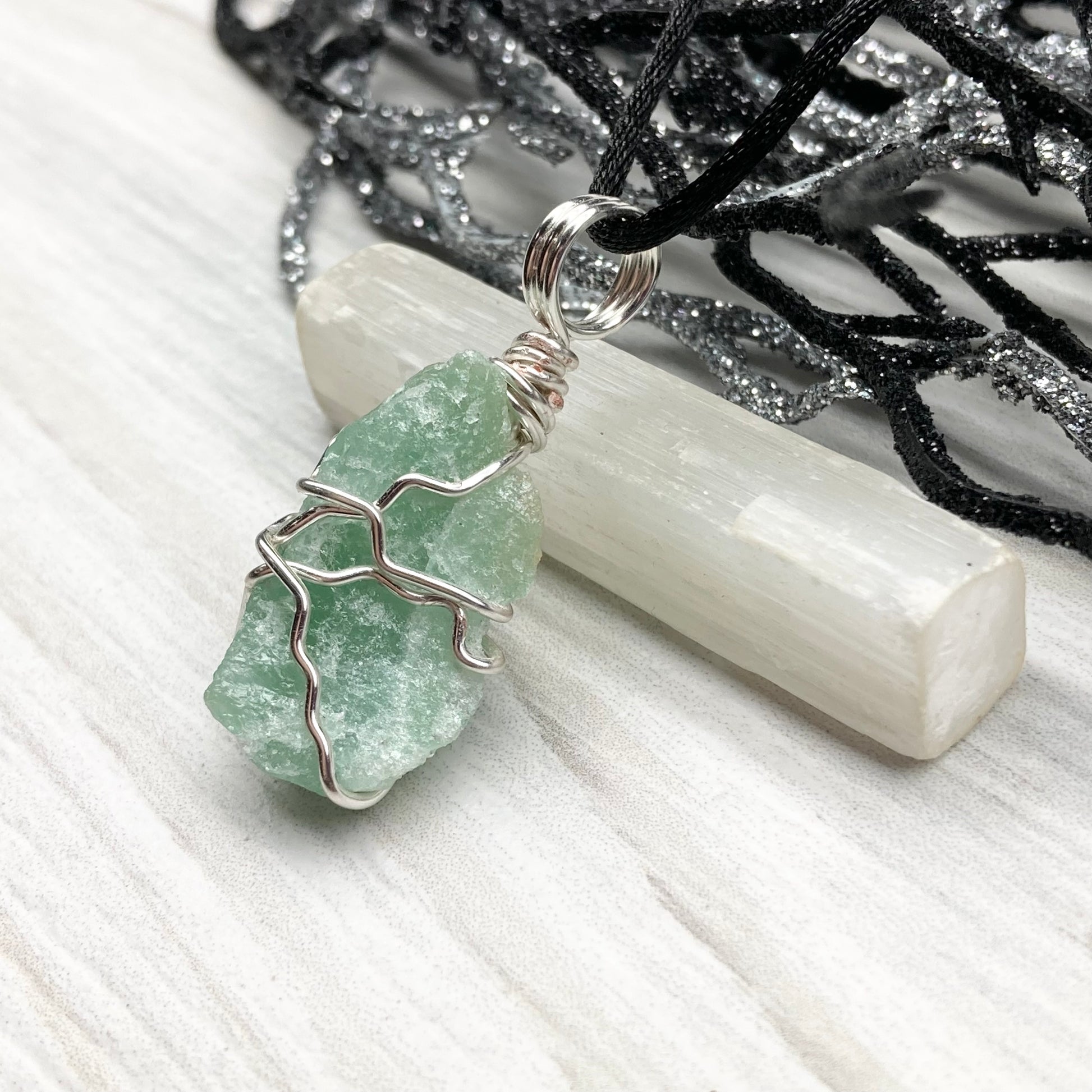 Green Aventurine necklace. Raw Green Aventurine stone wrapped with silver colored copper wire. Comes on a black chain. Wire wrapped green crystal pendant. 