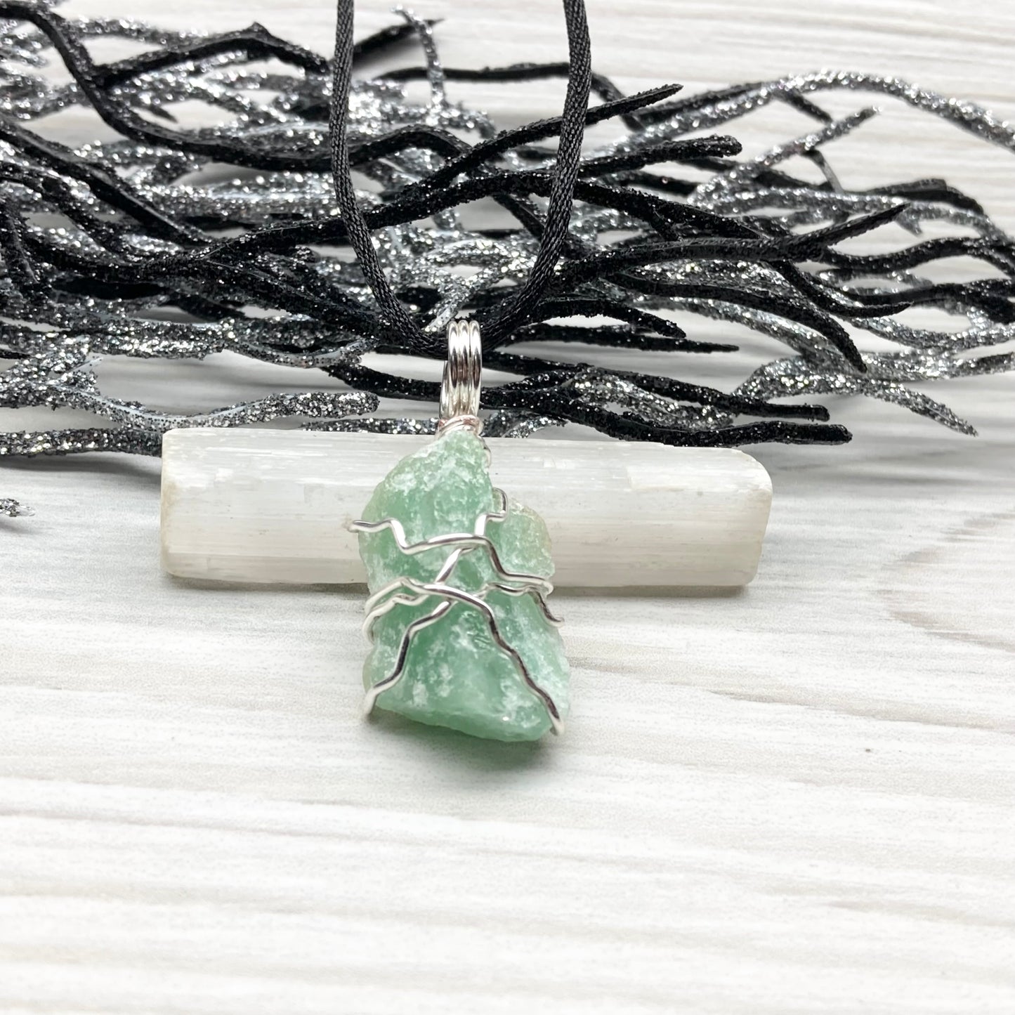 Green Aventurine necklace. Raw Green Aventurine stone wrapped with silver colored copper wire. Comes on a black chain. Wire wrapped green crystal pendant. 