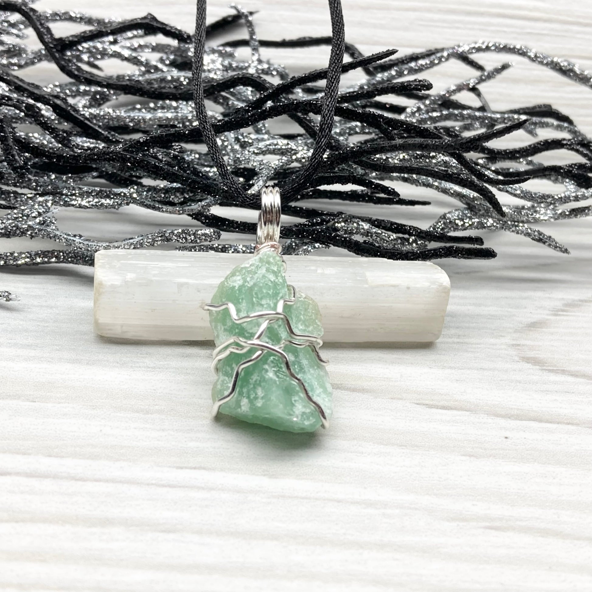 Green Aventurine necklace. Raw Green Aventurine stone wrapped with silver colored copper wire. Comes on a black chain. Wire wrapped green crystal pendant. 