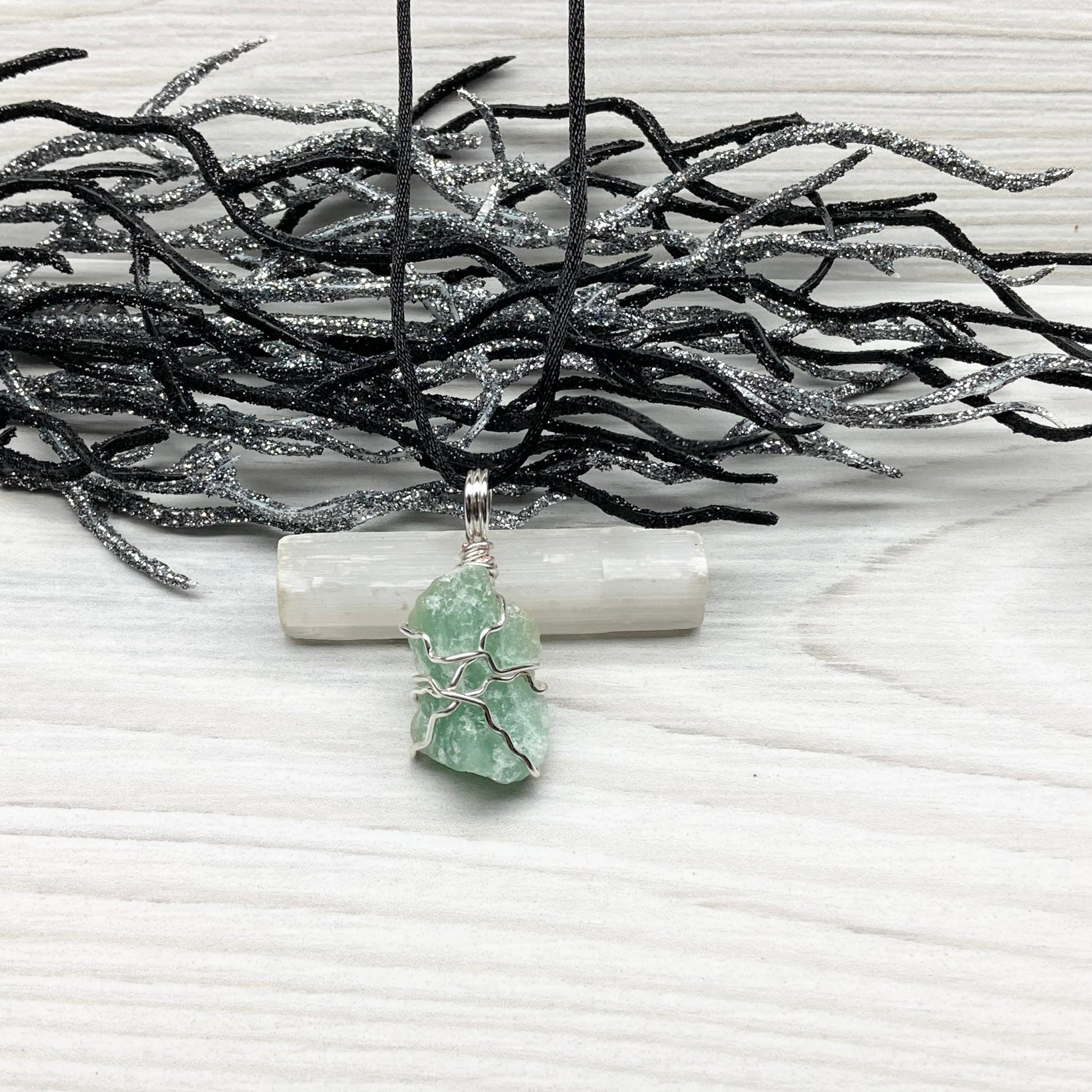 Green Aventurine necklace. Raw Green Aventurine stone wrapped with silver colored copper wire. Comes on a black chain. Wire wrapped green crystal pendant. 