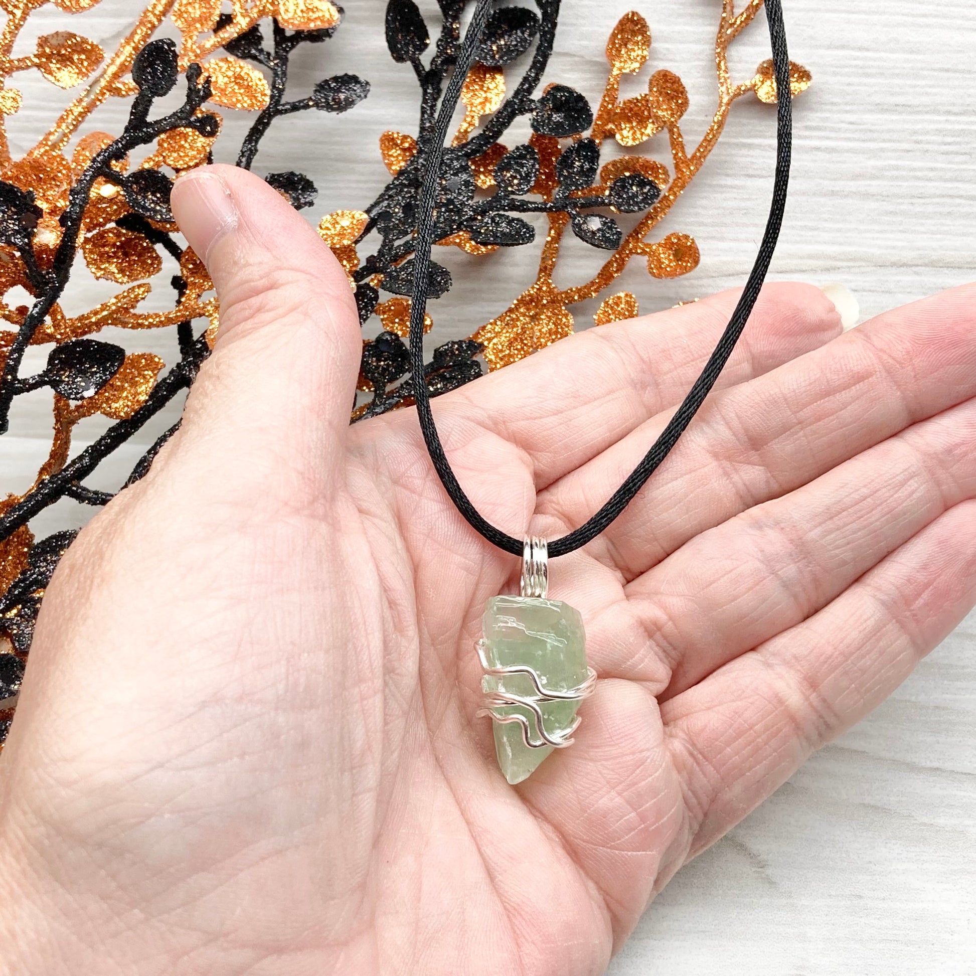 Green Calcite Necklace. Green Calcite wrapped with silver colored copper wire. Comes on a black chain. Wire wrapped green crystal pendant. 