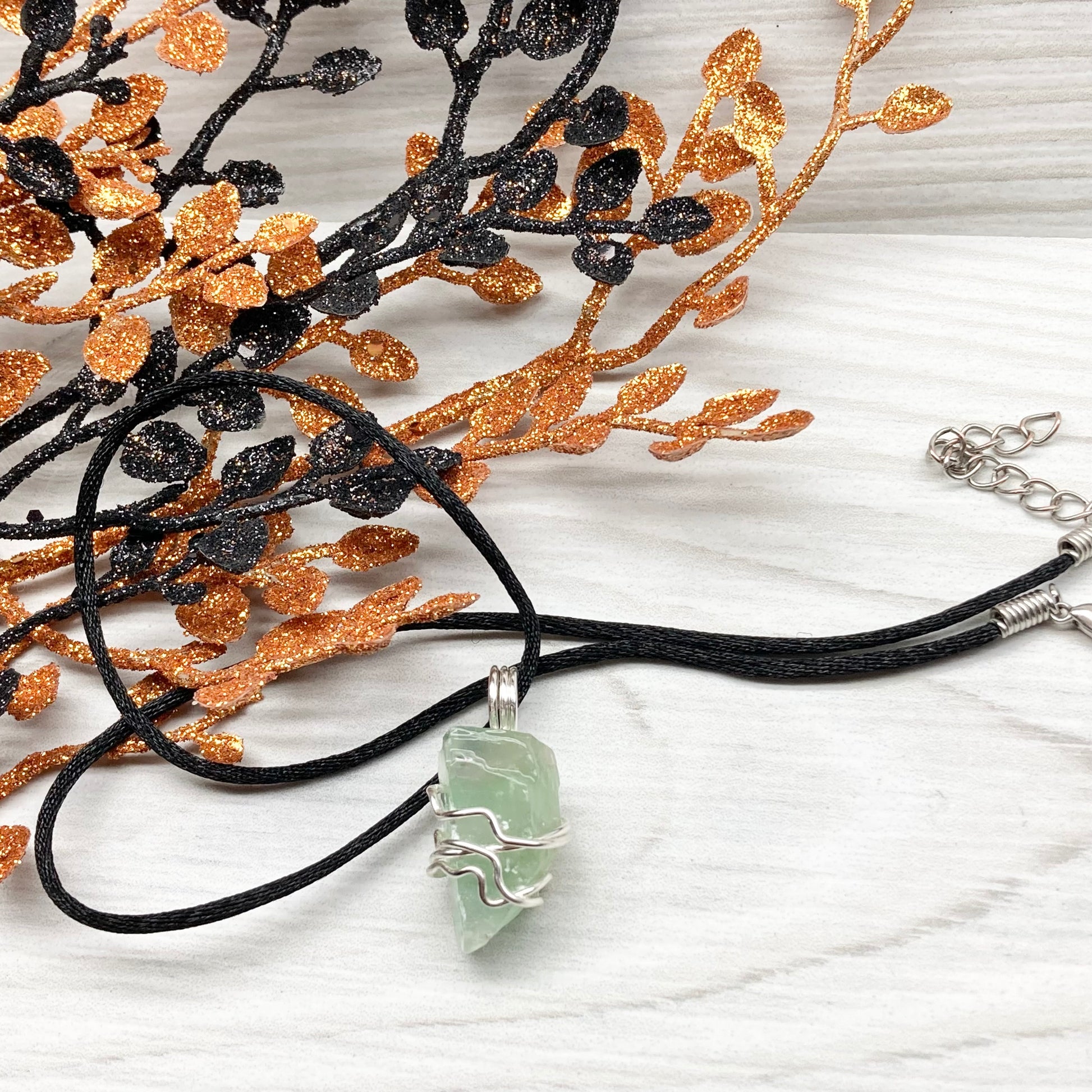 Green Calcite Necklace. Green Calcite wrapped with silver colored copper wire. Comes on a black chain. Wire wrapped green crystal pendant. 