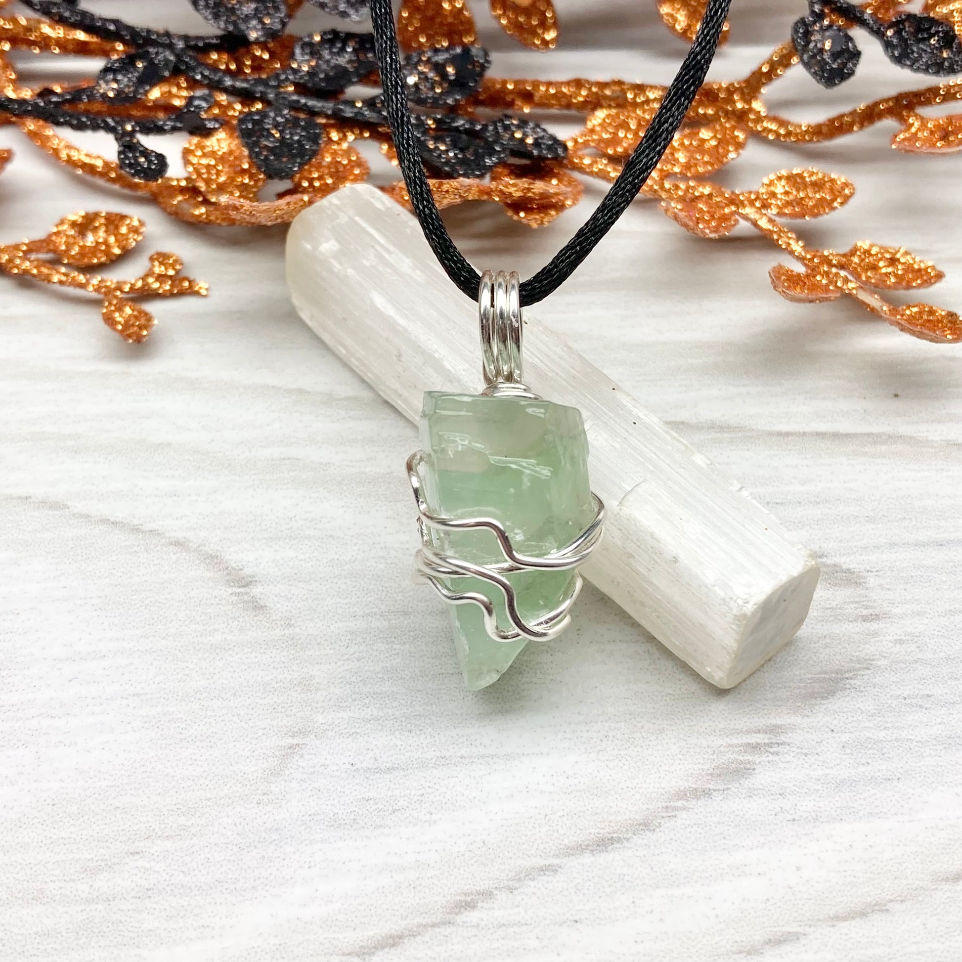 Green Calcite Necklace. Green Calcite wrapped with silver colored copper wire. Comes on a black chain. Wire wrapped green crystal pendant. 