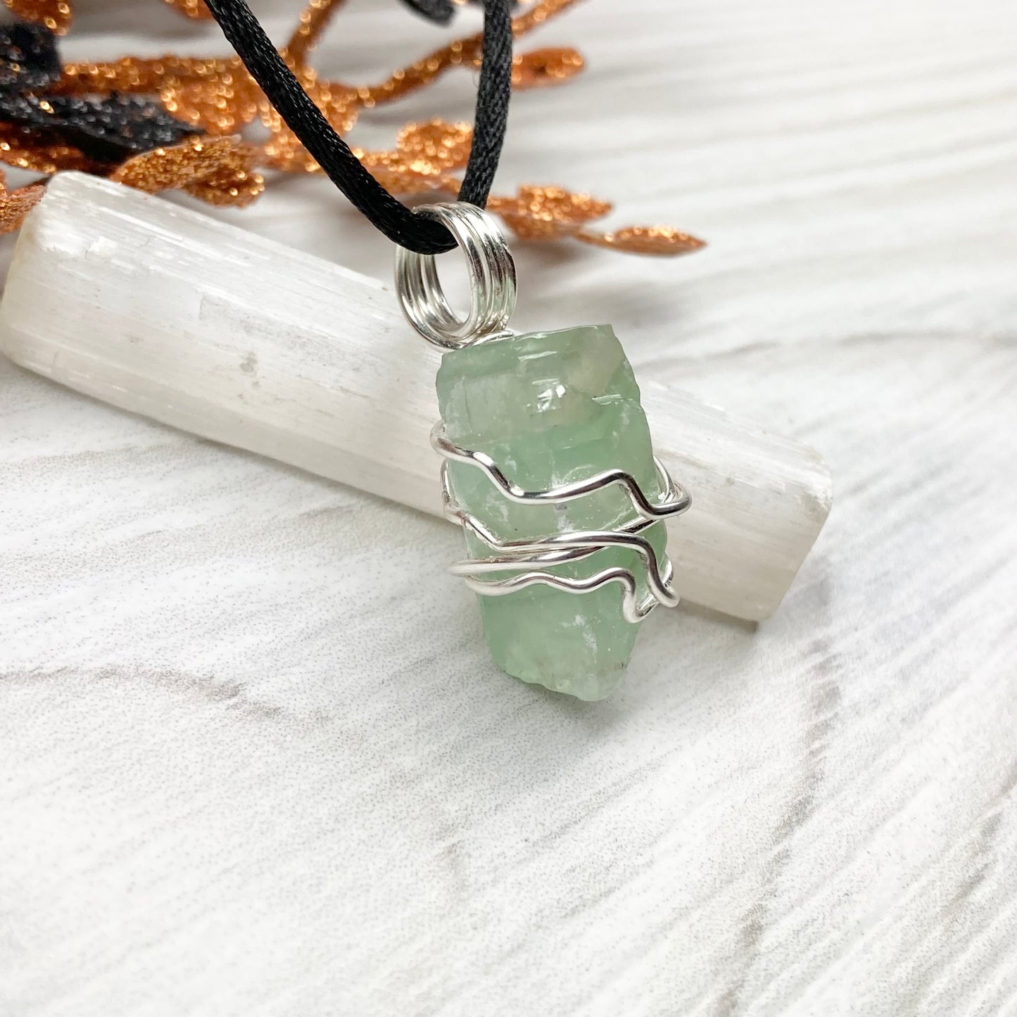 Green Calcite Necklace. Green Calcite wrapped with silver colored copper wire. Comes on a black chain. Wire wrapped green crystal pendant. 