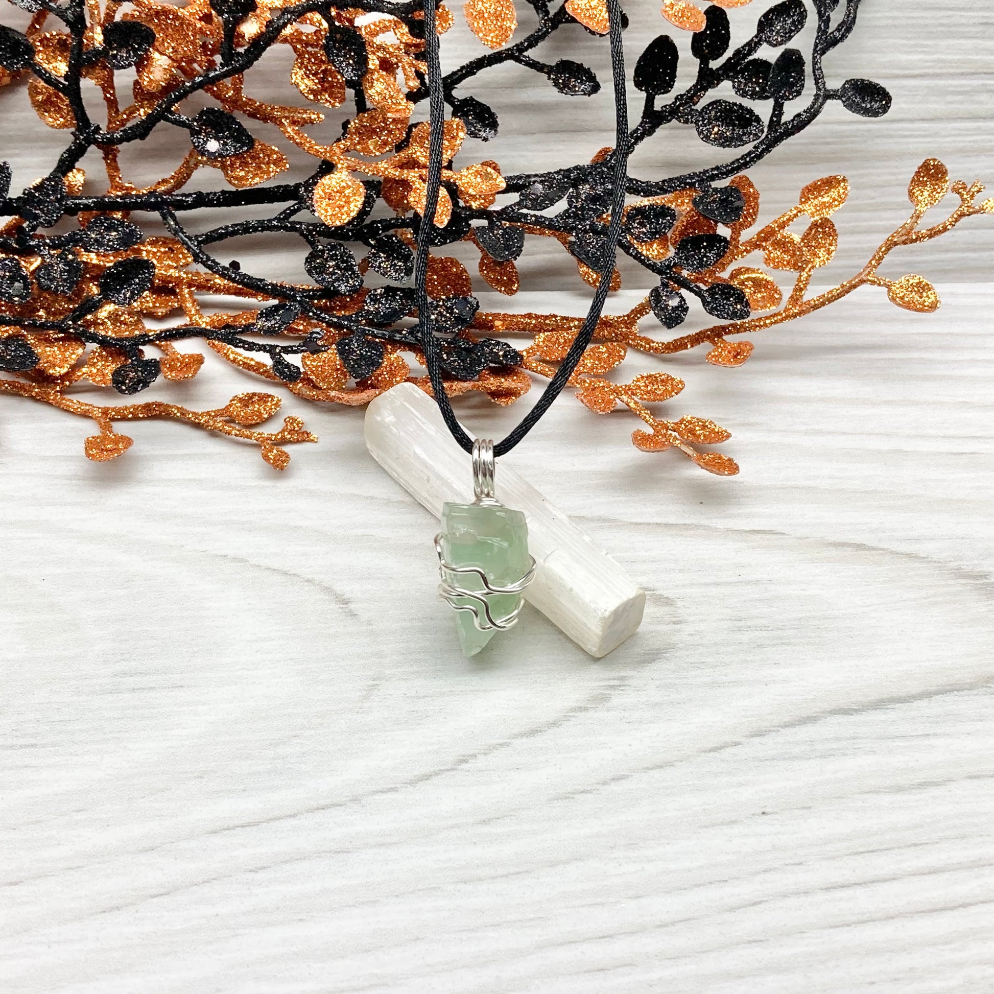 Green Calcite Necklace. Green Calcite wrapped with silver colored copper wire. Comes on a black chain. Wire wrapped green crystal pendant. 