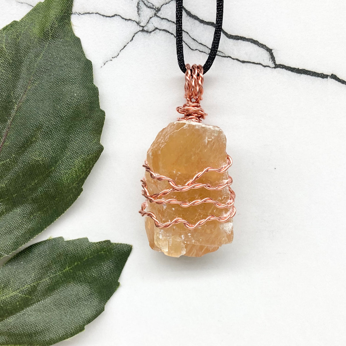 Honey Calcite necklace. Raw chunky yellow stone wrapped with pure copper wire. Hangs on a black chain. Metaphysical handmade jewelry.