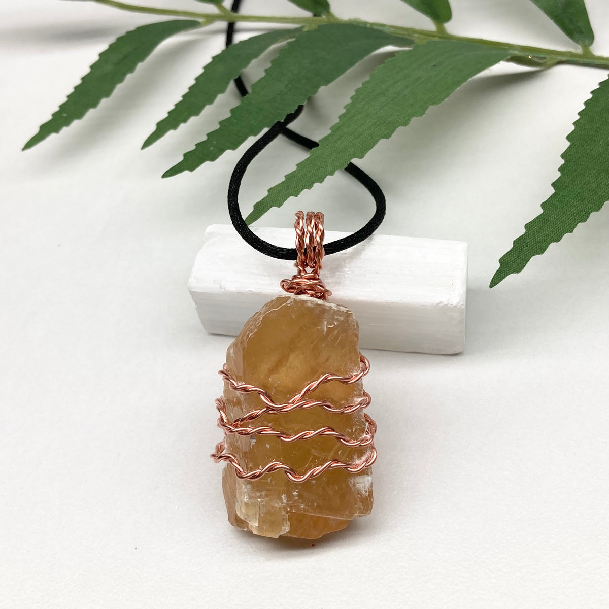 Honey Calcite necklace. Raw chunky yellow stone wrapped with pure copper wire. Hangs on a black chain. Metaphysical handmade jewelry.