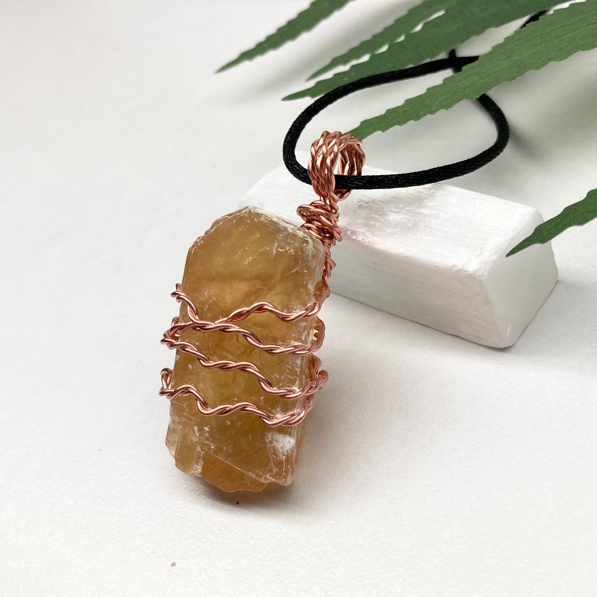 Honey Calcite necklace. Raw chunky yellow stone wrapped with pure copper wire. Hangs on a black chain. Metaphysical handmade jewelry.