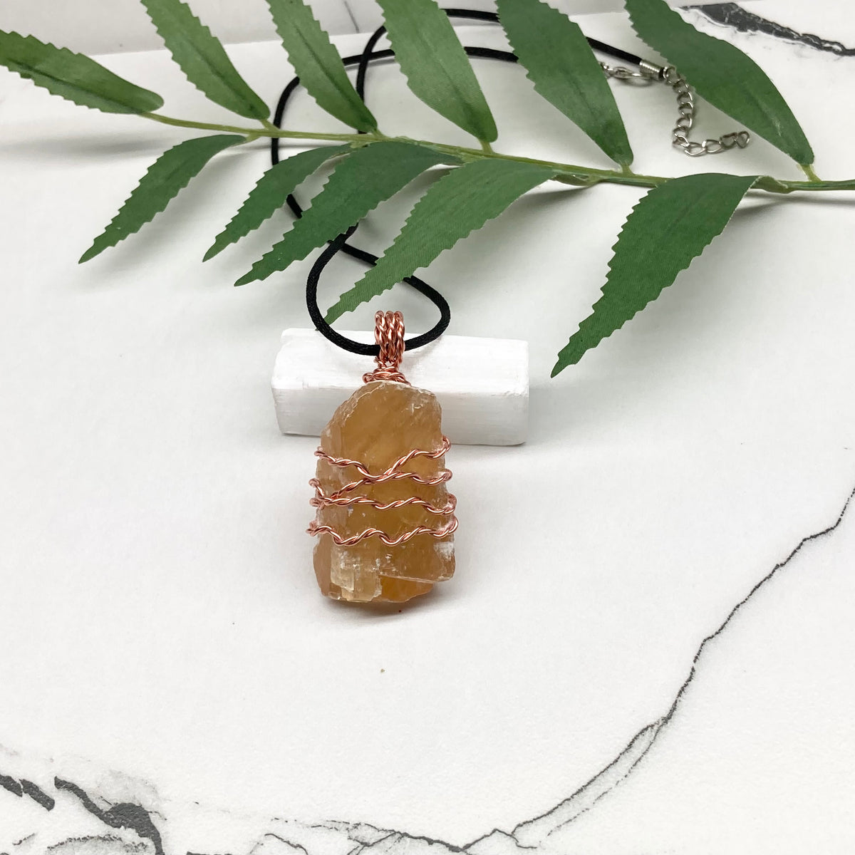 Honey Calcite necklace. Raw chunky yellow stone wrapped with pure copper wire. Hangs on a black chain. Metaphysical handmade jewelry.
