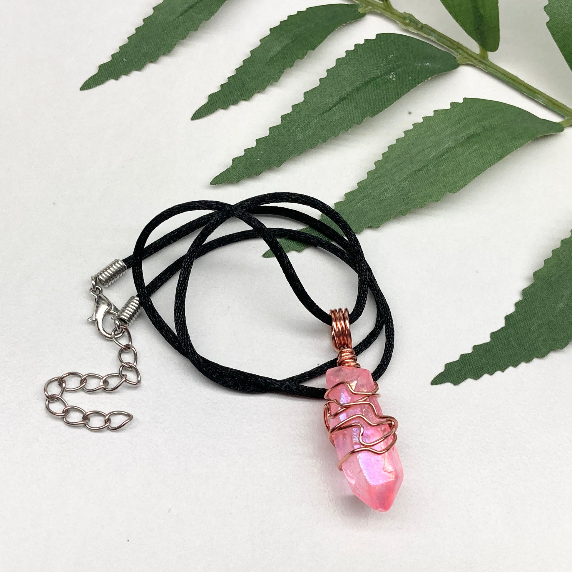 Pink Aura Quartz Necklace. Pink Aura Quartz crystal with iridescent shimmer, wrapped in pure copper wire. Hangs on a black chain. 
