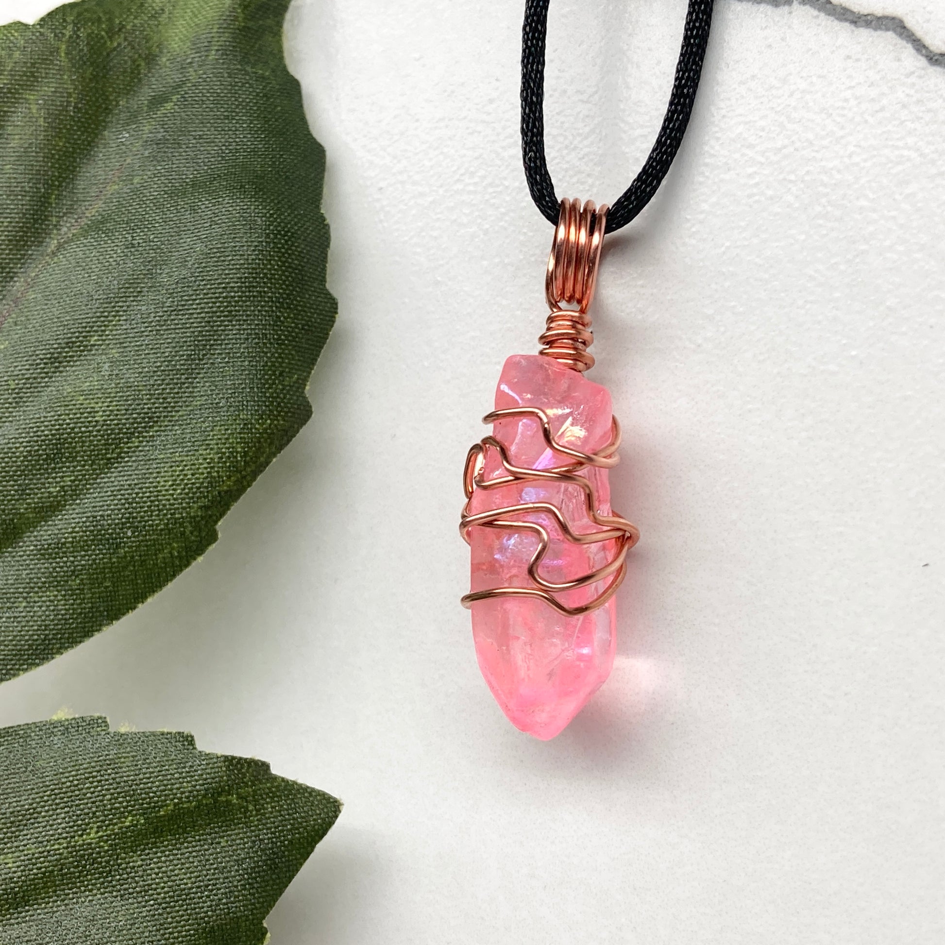 Pink Aura Quartz Necklace. Pink Aura Quartz crystal with iridescent shimmer, wrapped in pure copper wire. Hangs on a black chain. 