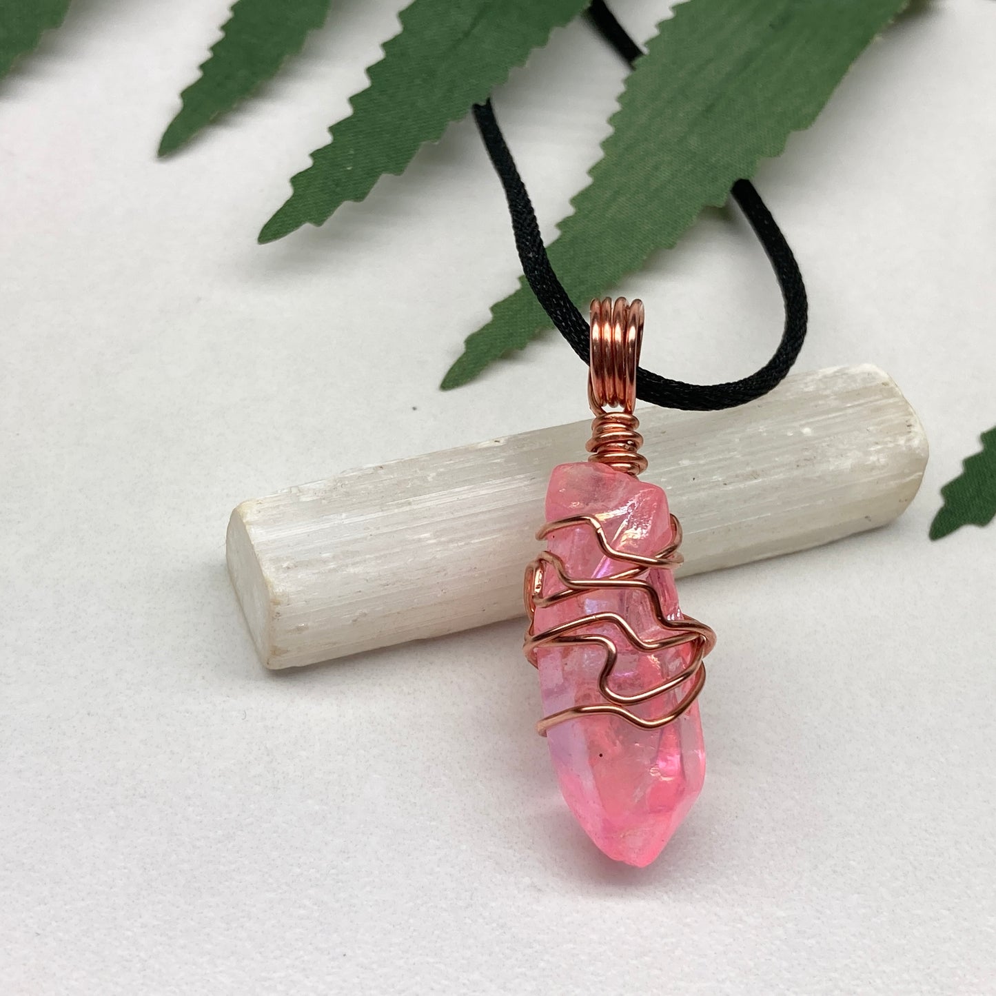 Pink Aura Quartz Necklace. Pink Aura Quartz crystal with iridescent shimmer, wrapped in pure copper wire. Hangs on a black chain. 