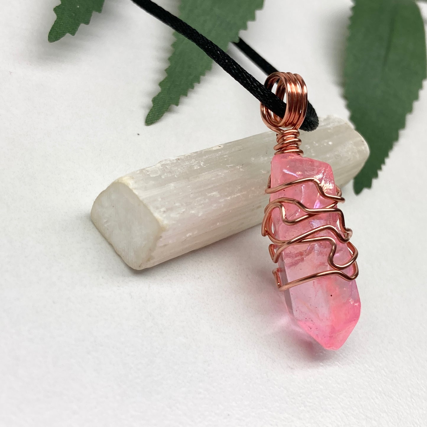 Pink Aura Quartz Necklace. Pink Aura Quartz crystal with iridescent shimmer, wrapped in pure copper wire. Hangs on a black chain. 