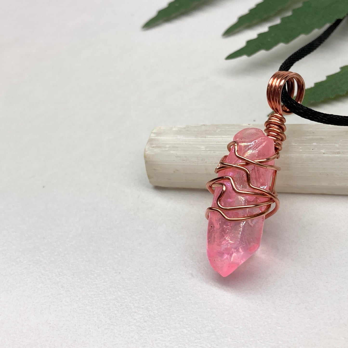 Pink Aura Quartz Necklace. Pink Aura Quartz crystal with iridescent shimmer, wrapped in pure copper wire. Hangs on a black chain. 