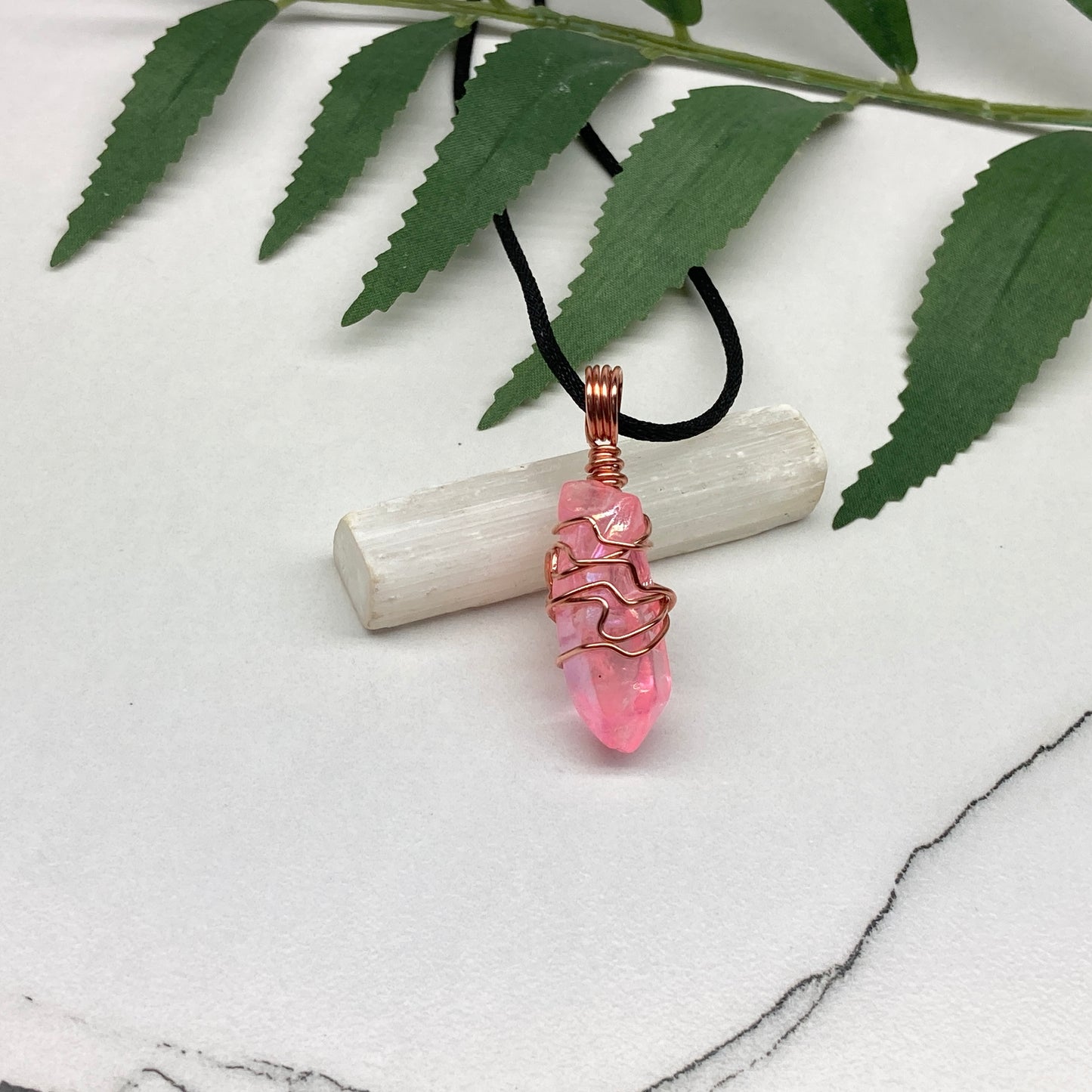 Pink Aura Quartz Necklace. Pink Aura Quartz crystal with iridescent shimmer, wrapped in pure copper wire. Hangs on a black chain. 