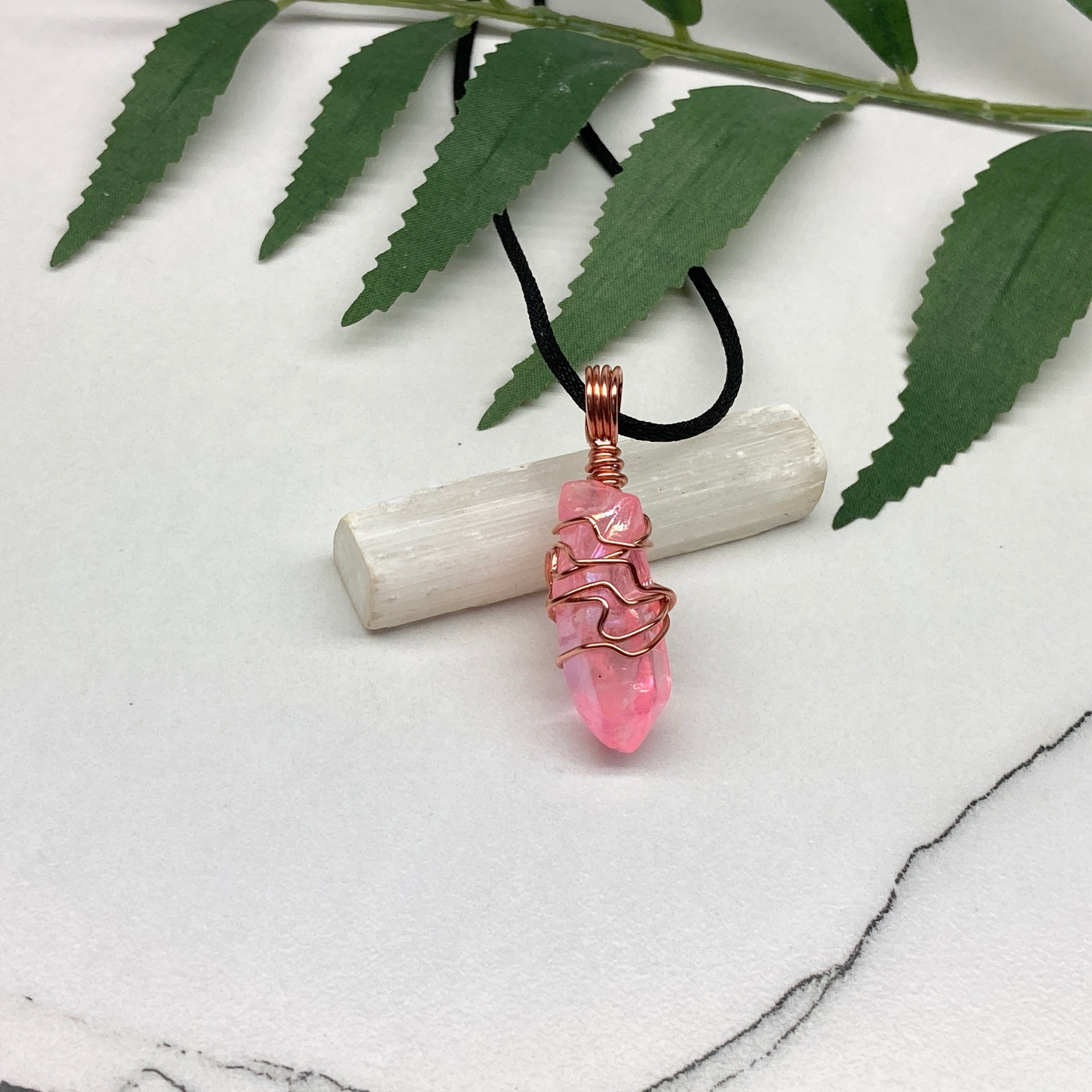 Pink Aura Quartz Necklace. Pink Aura Quartz crystal with iridescent shimmer, wrapped in pure copper wire. Hangs on a black chain. 
