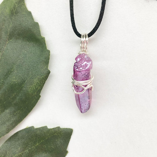 Hand-wrapped purple aura quartz pendant in silver-colored copper wire on a satin silk chain.